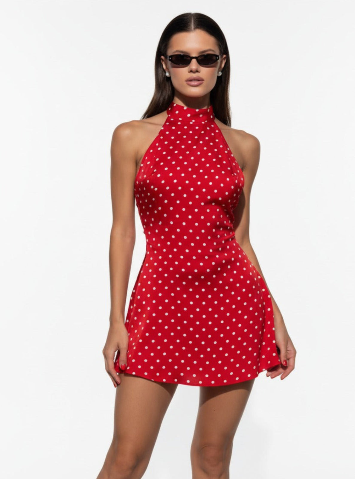 Woman wearing a red polka dot dress on a white background