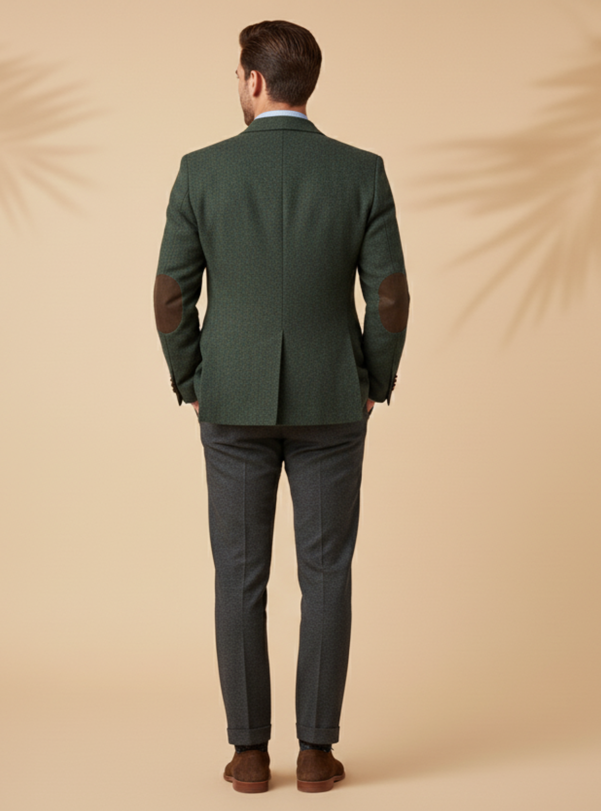 Man wearing a green suit standing against a beige background