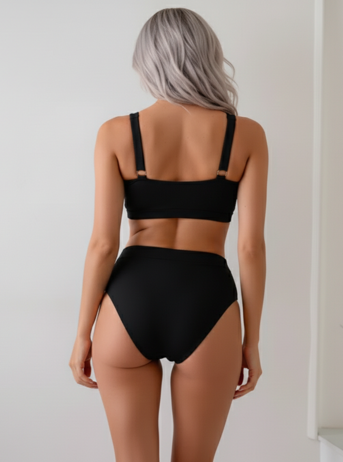 Person wearing a black bikini against a plain background