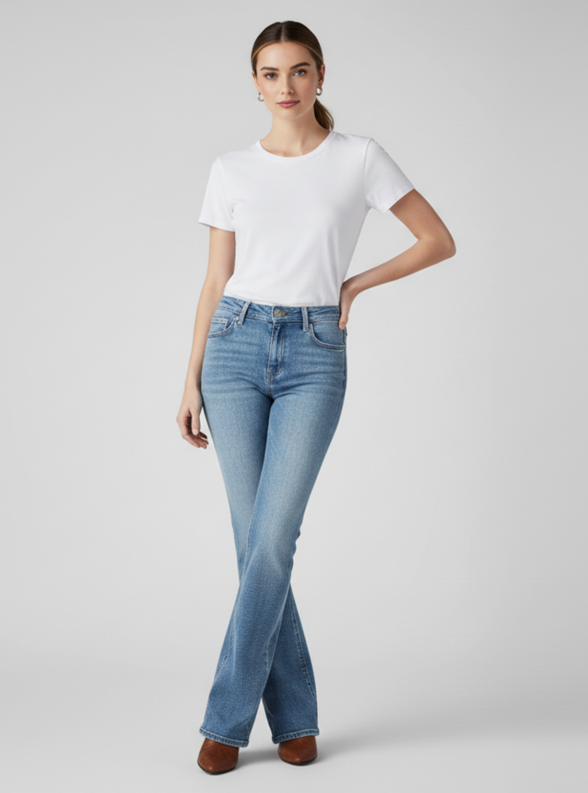 Woman wearing a white t-shirt and light blue jeans on a gray background