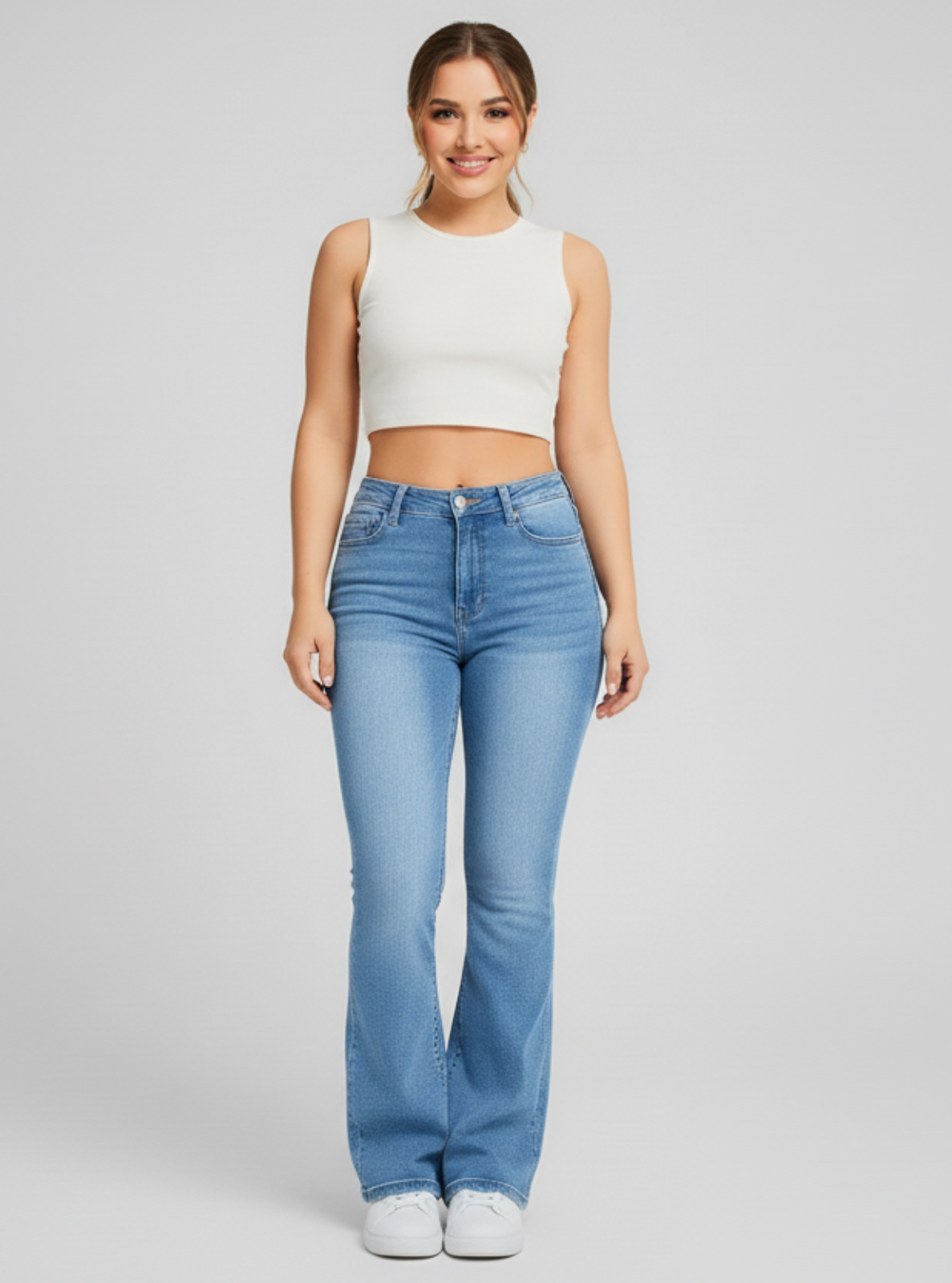 Woman wearing blue jeans and a white top on a gray background