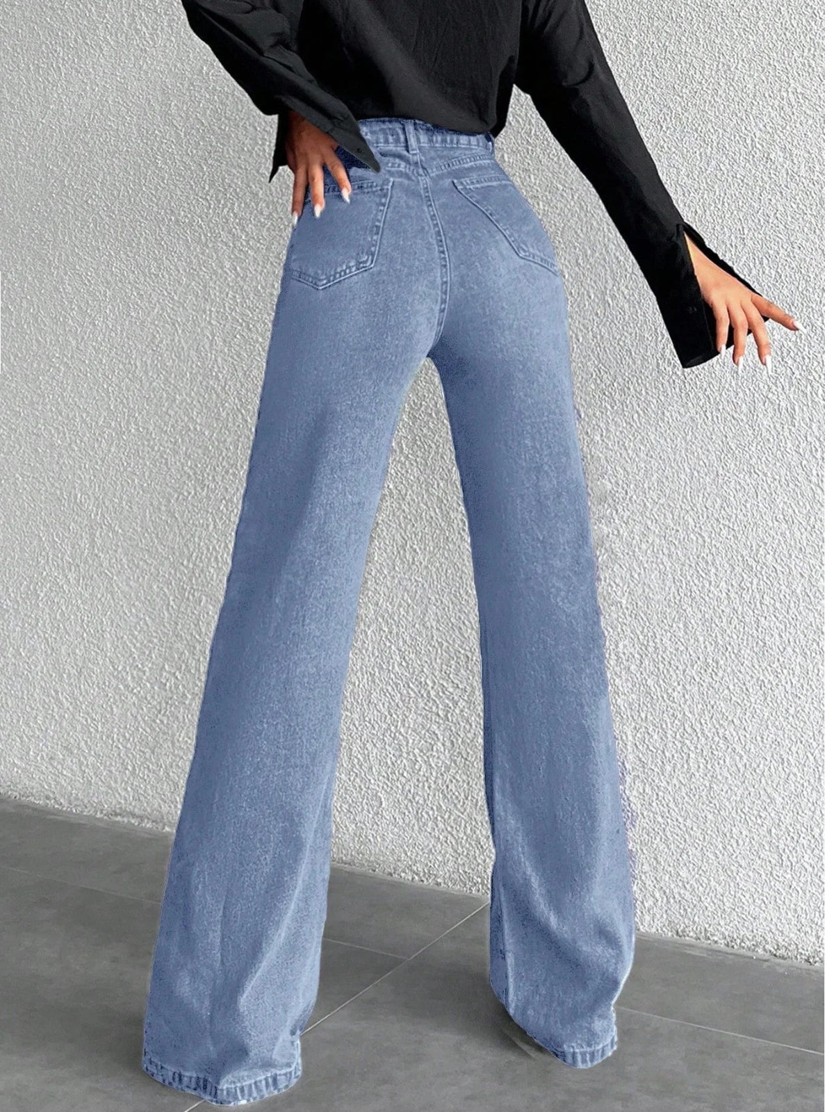Person wearing blue wide-leg jeans against a plain background