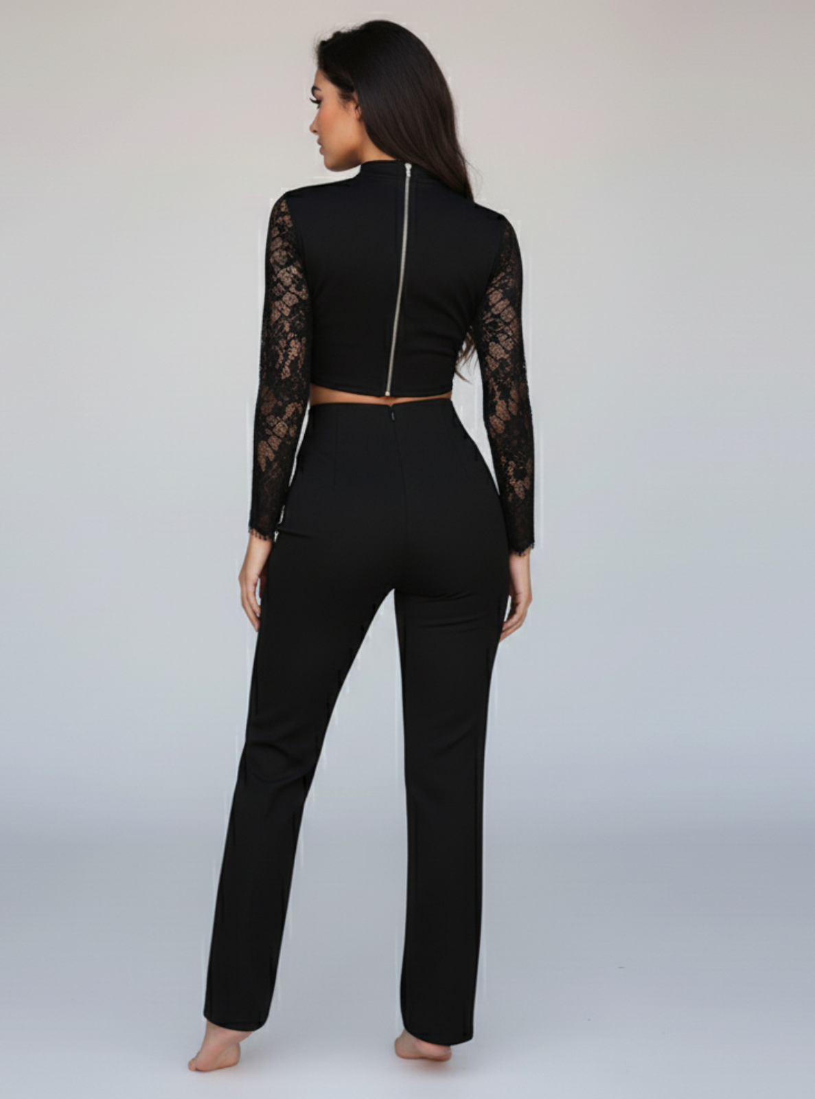Black outfit with lace sleeves on a plain background