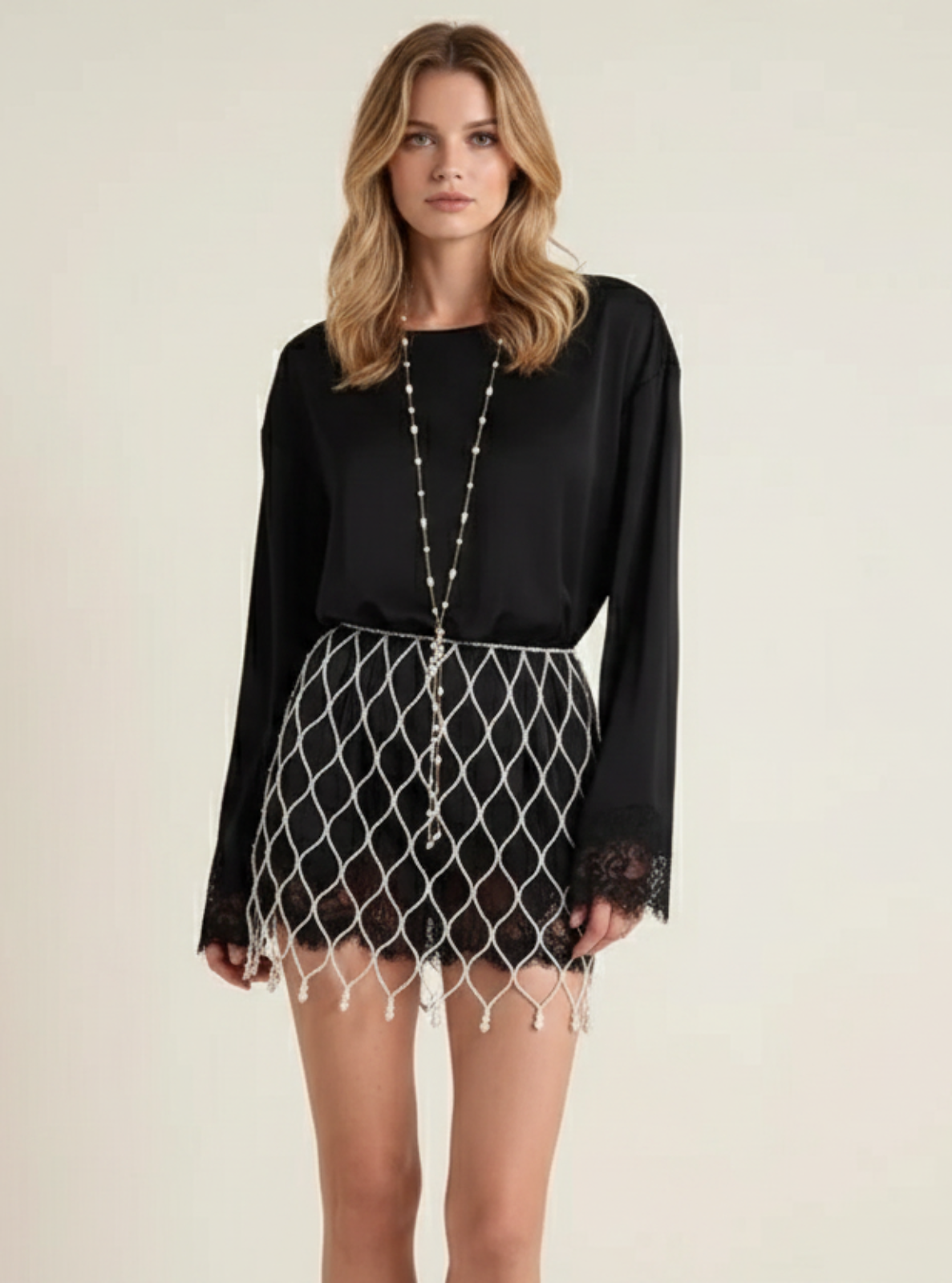 Woman wearing a black blouse and patterned skirt on a plain background