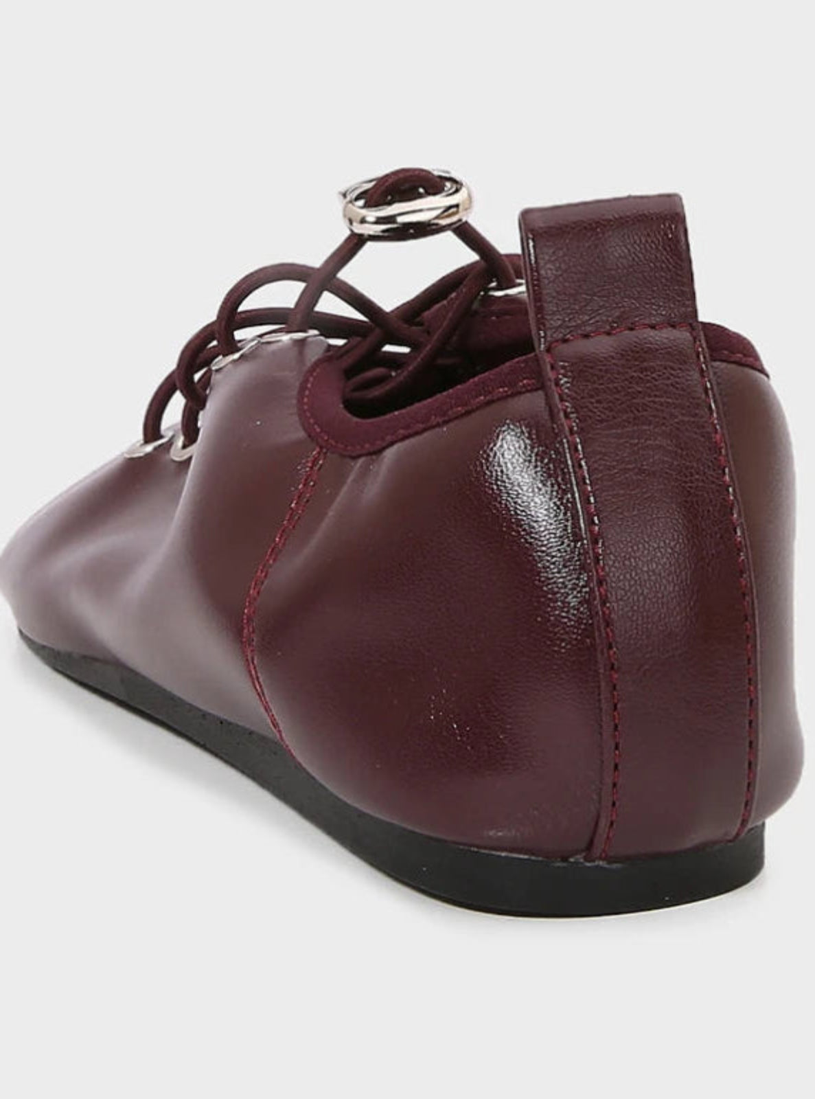 Maroon leather shoe with a strap on a white background