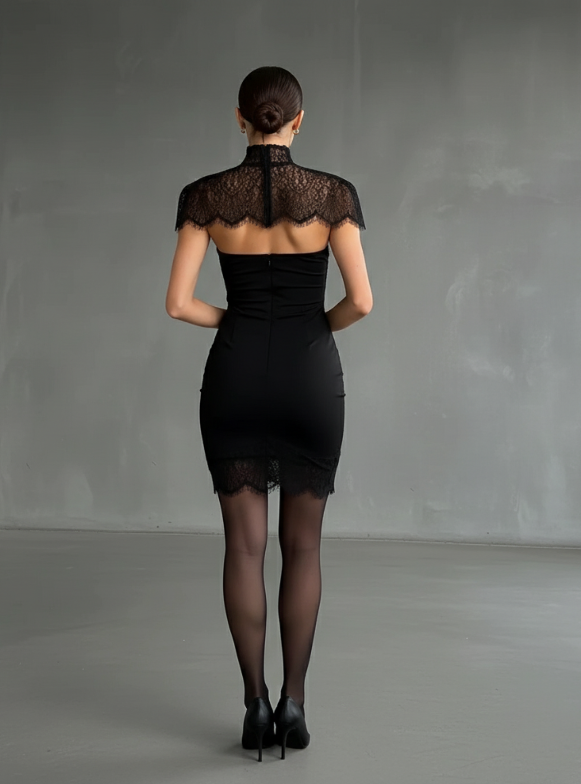 Woman wearing a black dress with lace detailing in a minimalistic setting