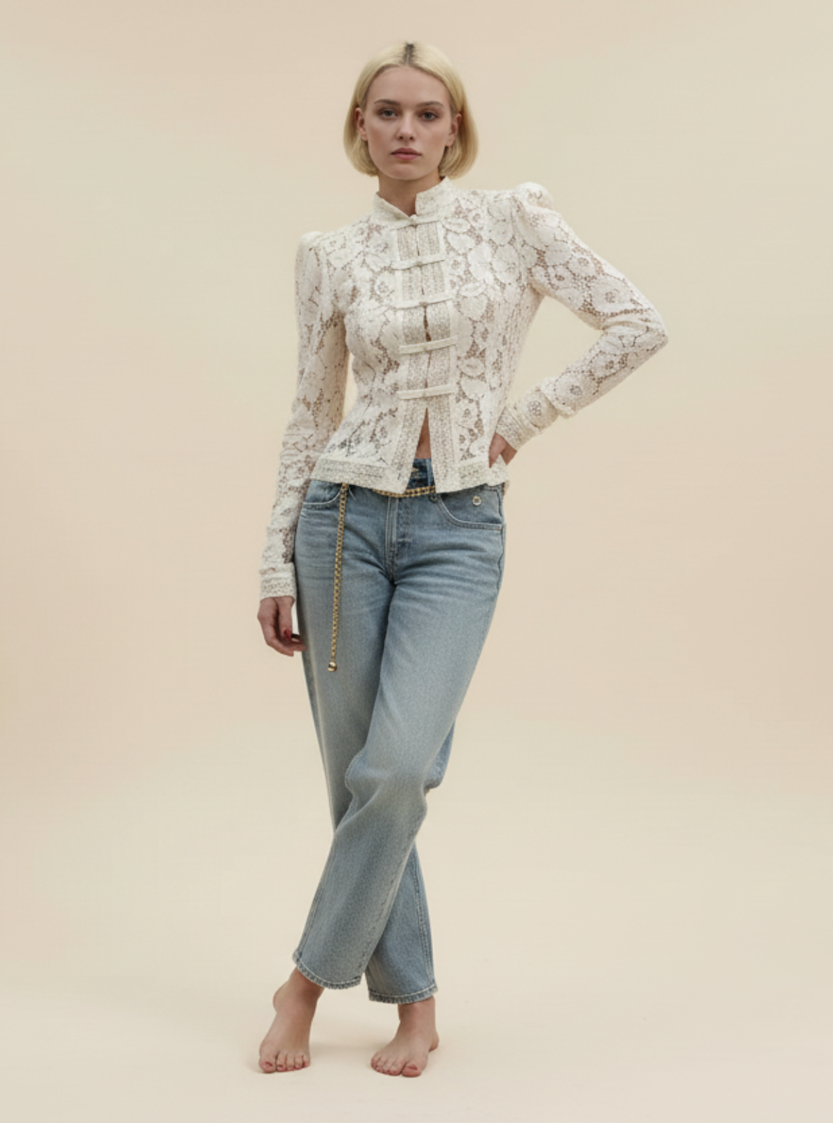 Woman wearing a white lace top and light blue jeans on a beige background