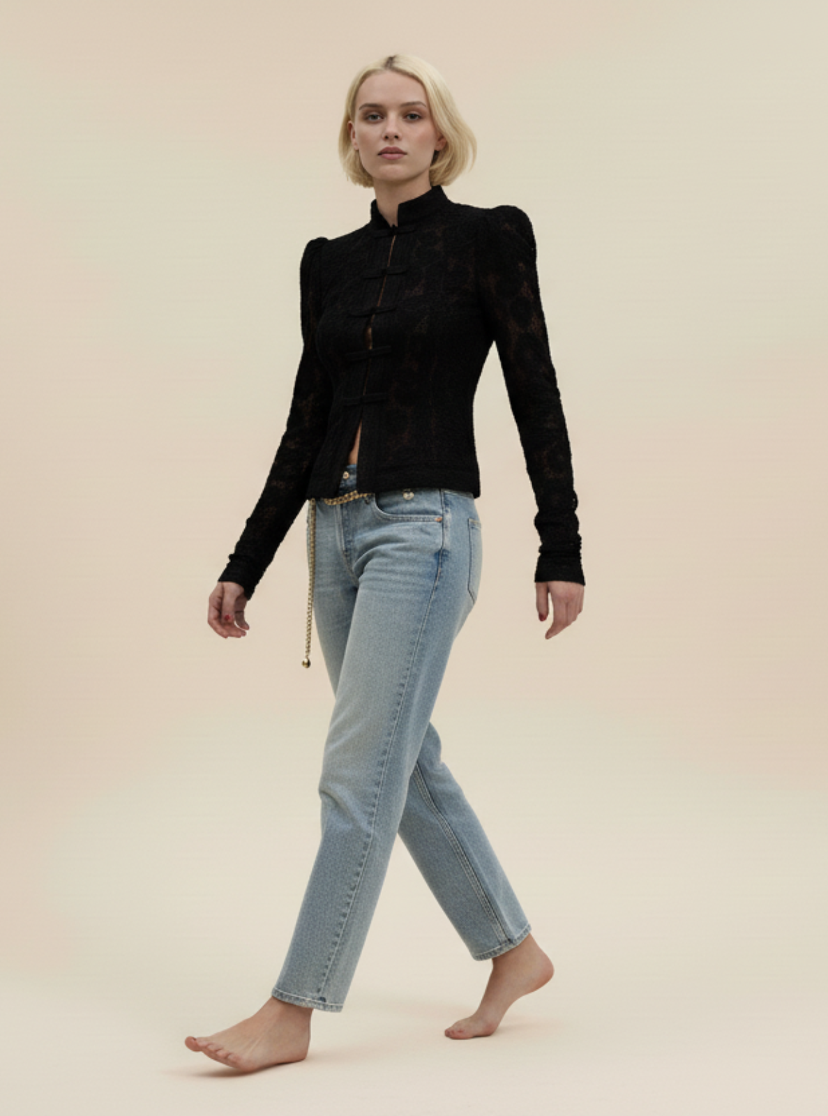 Woman wearing a black top and light blue jeans on a beige background