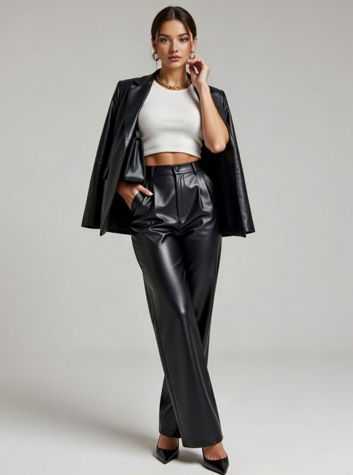 Woman wearing a black leather outfit with a white top on a gray background