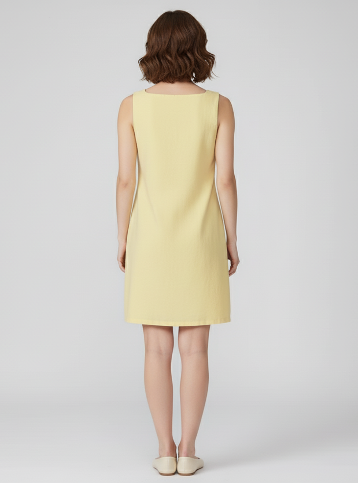Woman wearing a yellow dress on a white background