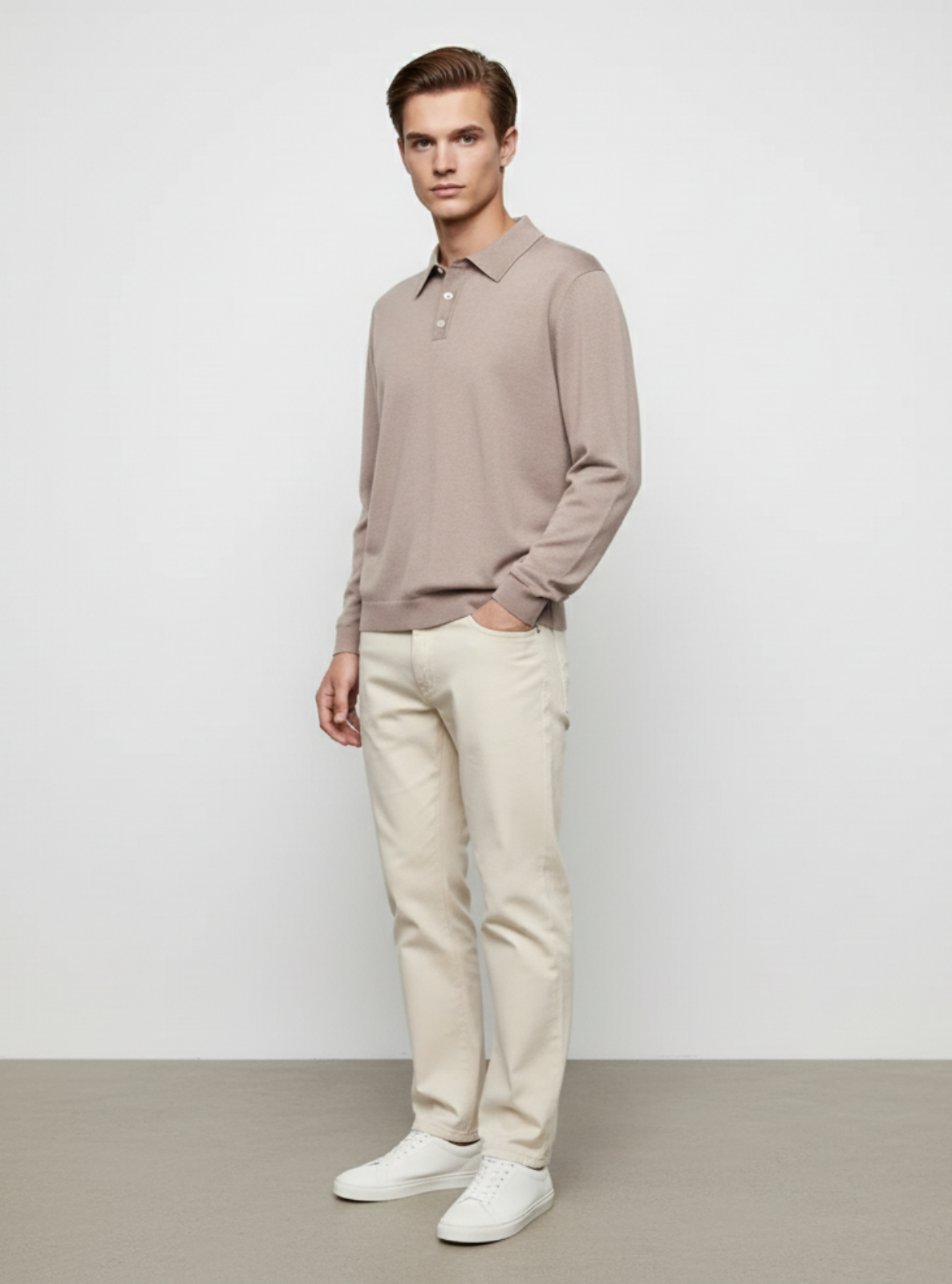 Man wearing a beige long-sleeve shirt and light-colored pants against a plain background