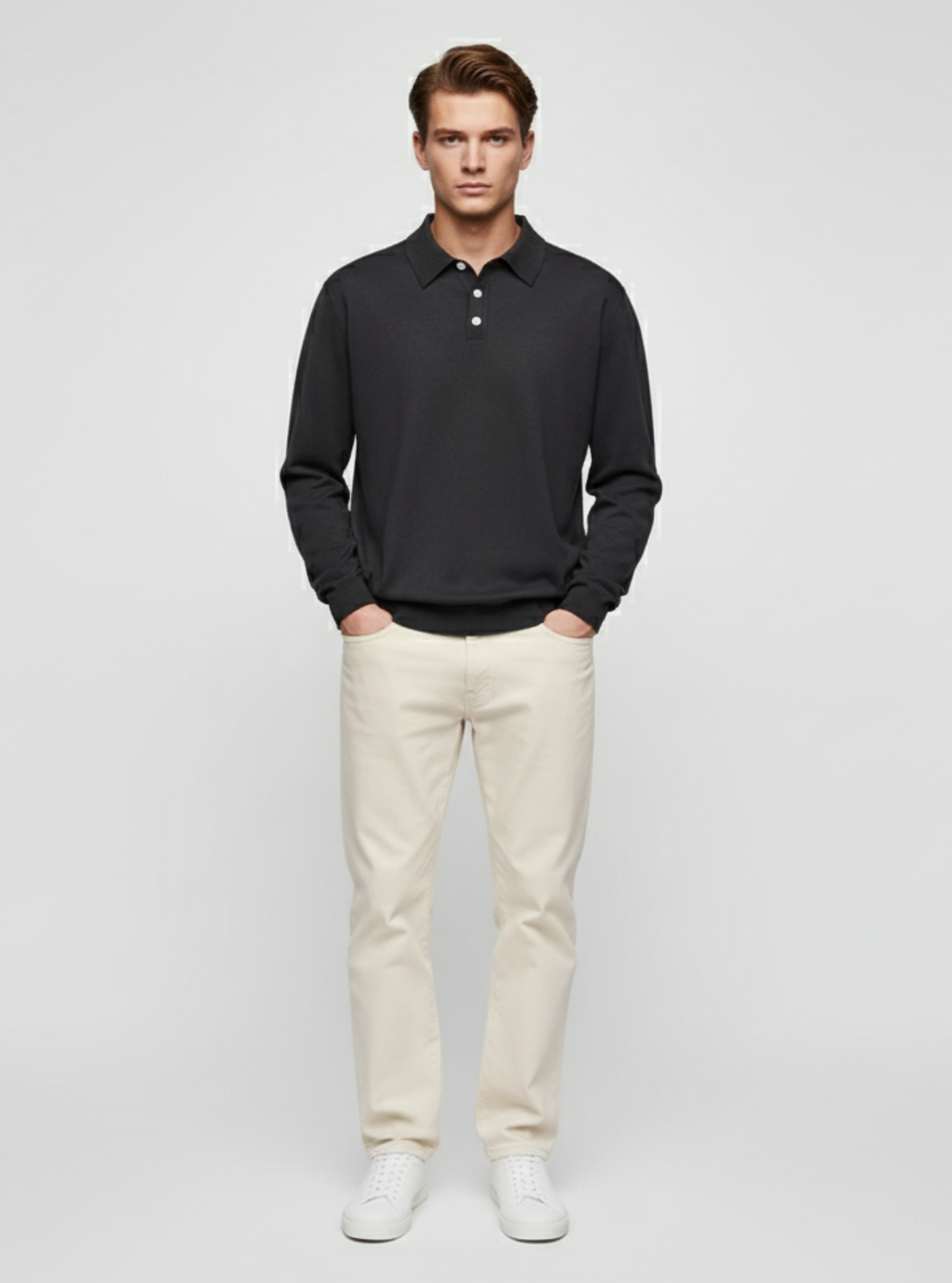 Man wearing a black long-sleeve polo shirt and white pants on a light gray background