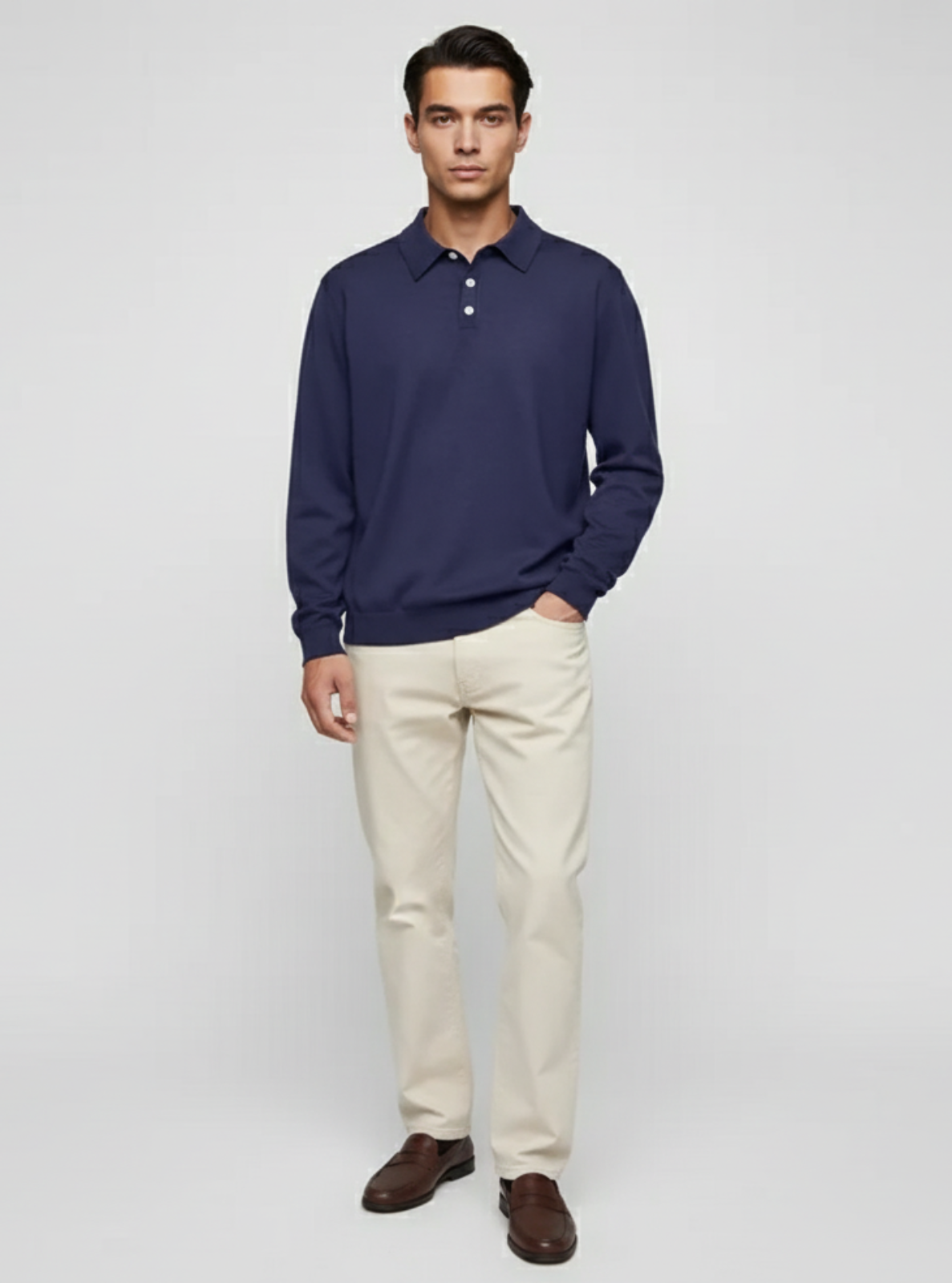 Man wearing a navy polo shirt and beige pants on a white background