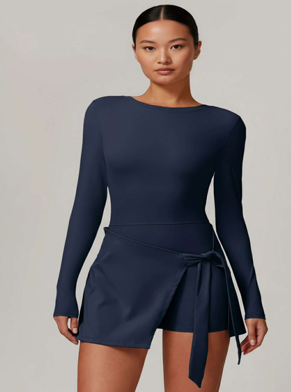 Navy blue long-sleeve dress with a tie detail on a plain background