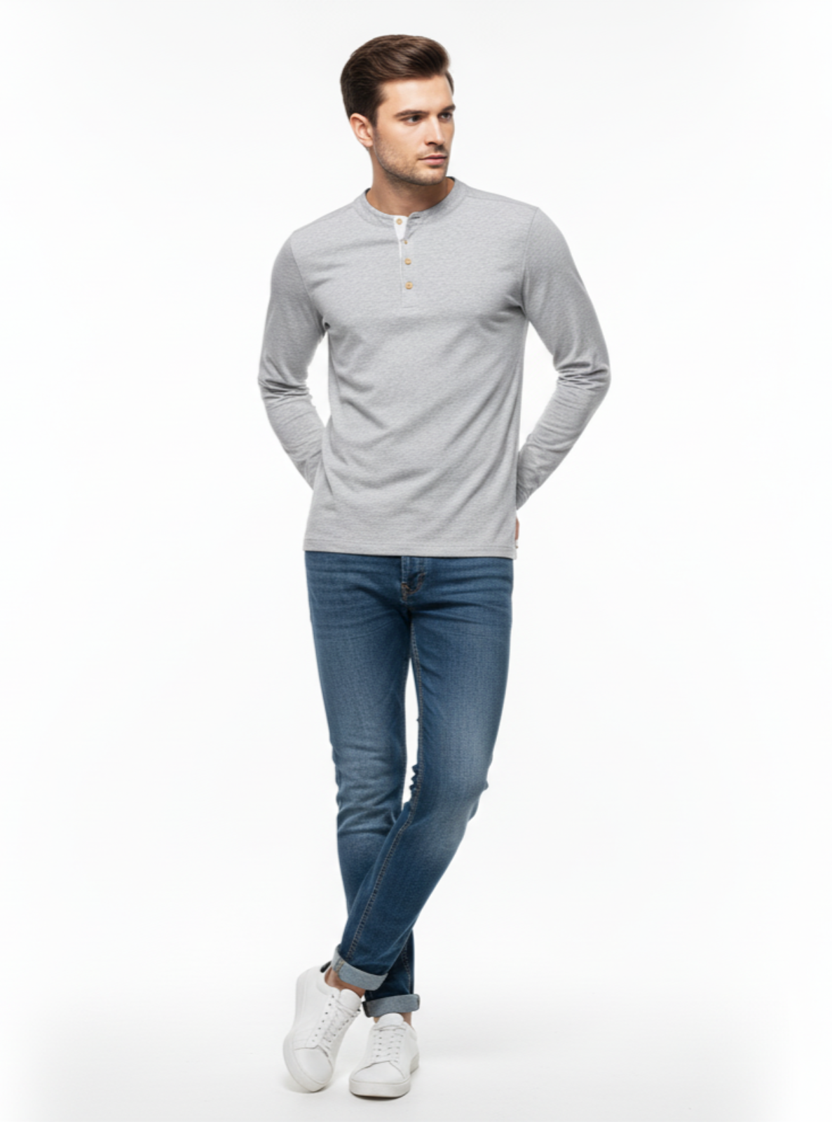 Man wearing a gray long-sleeve shirt and blue jeans on a white background