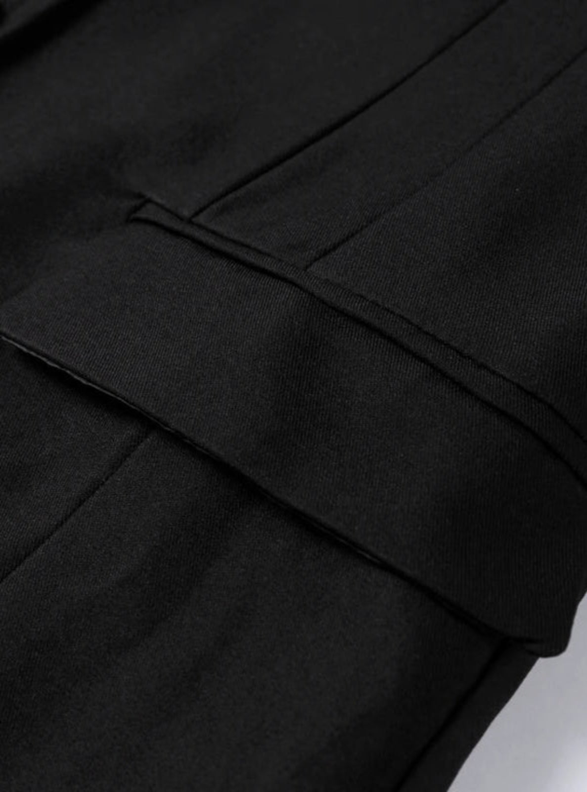 Close-up of a black coat with a collar on a light gray background