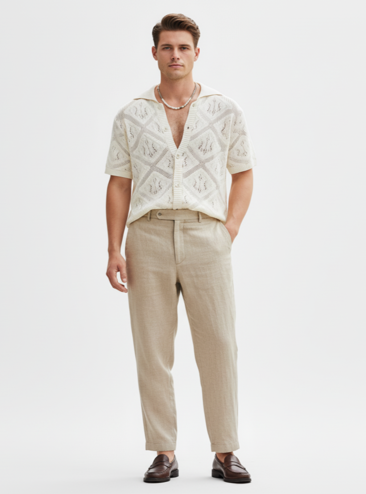 Man wearing a patterned shirt and beige pants on a white background