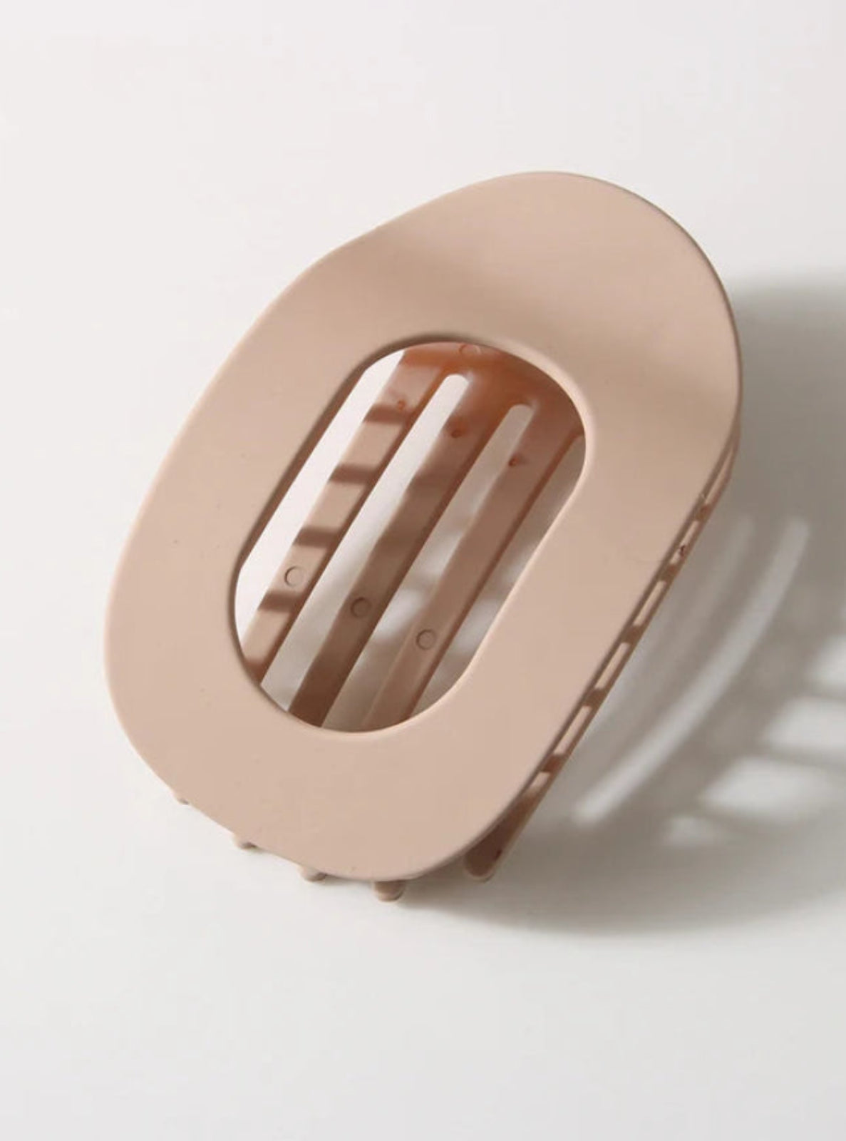 Beige soap dish with a bar of soap on a light gray background