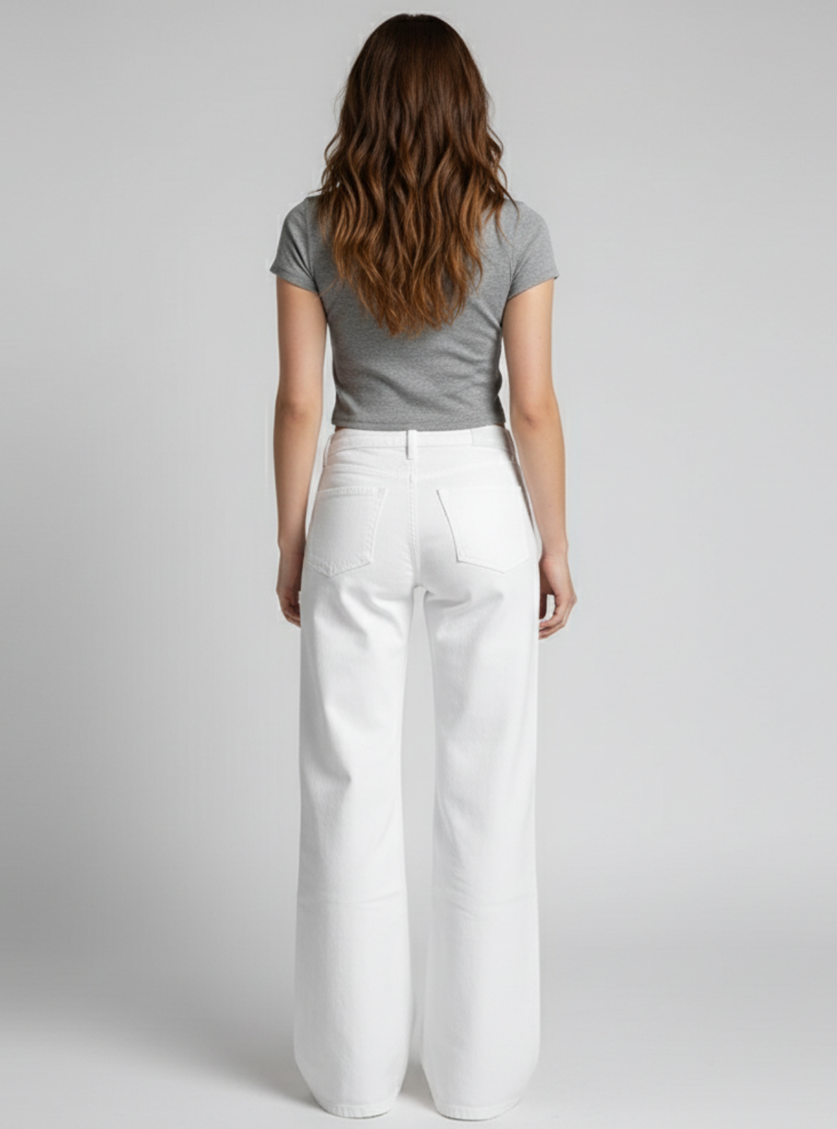 Person wearing a gray t-shirt and white pants on a plain background