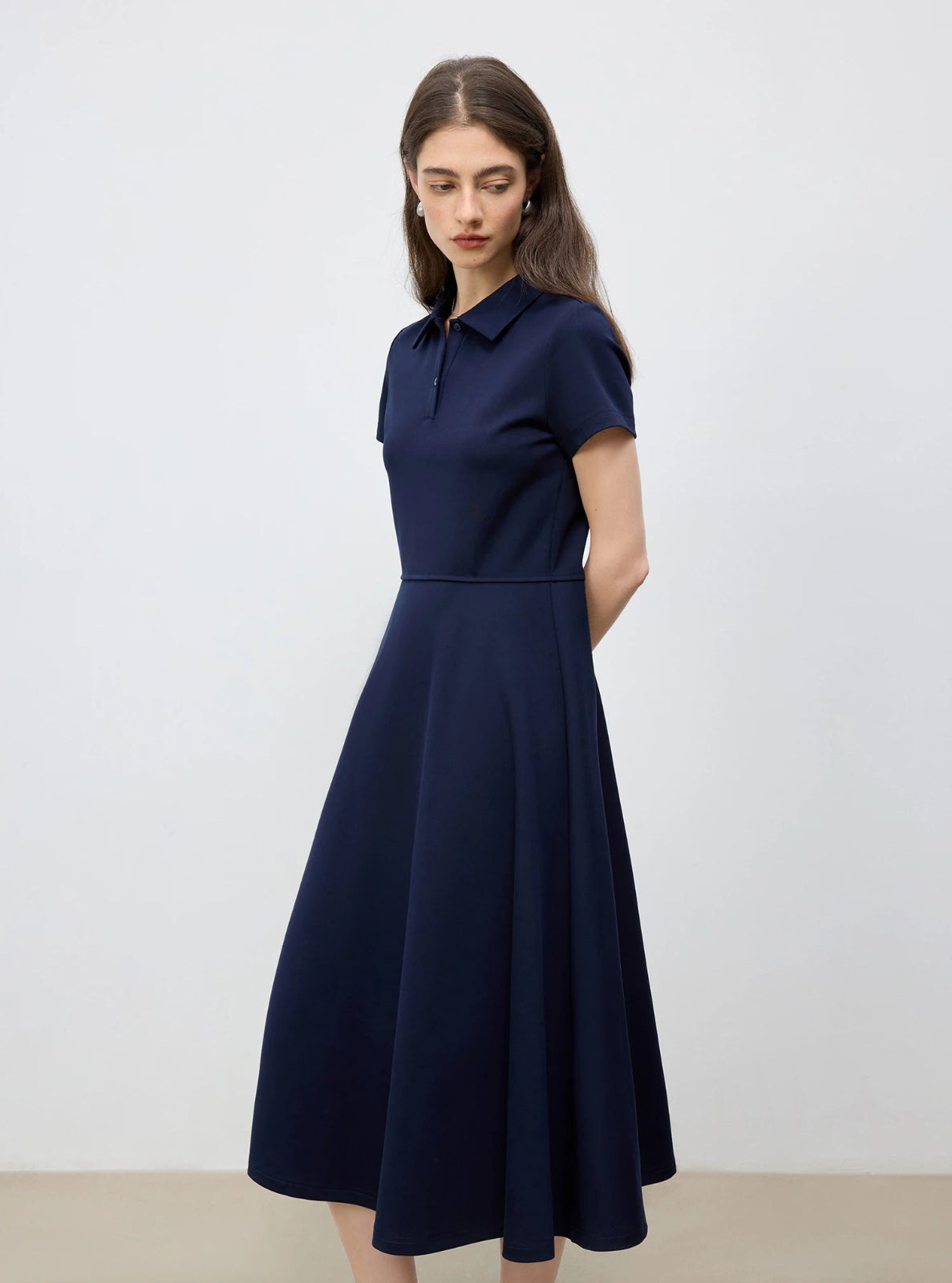 Woman wearing a navy blue dress against a white background