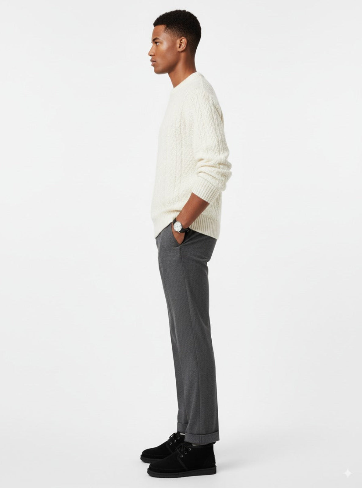 Man wearing a white sweater and gray pants on a white background