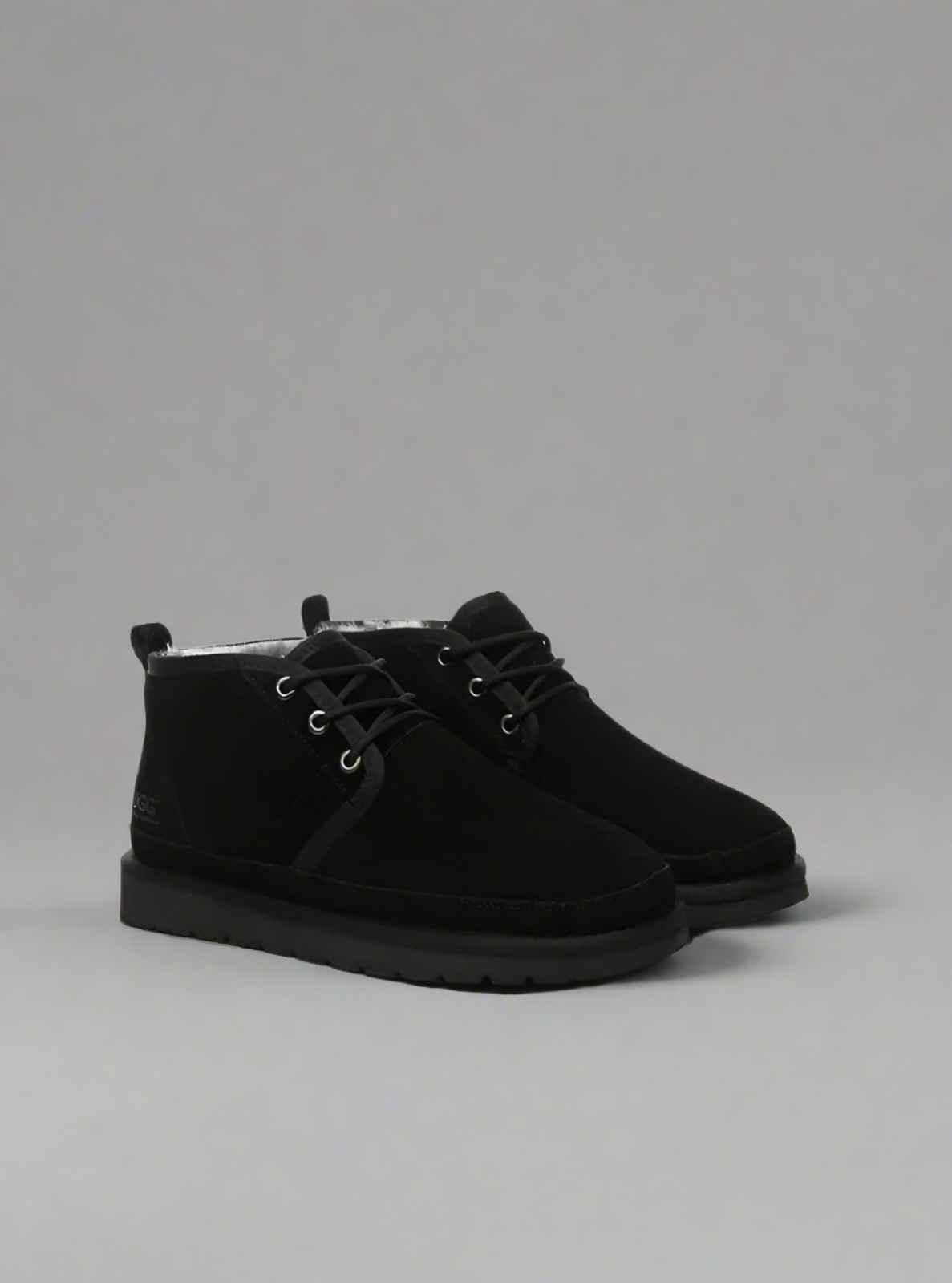 Black suede boots on a gray background