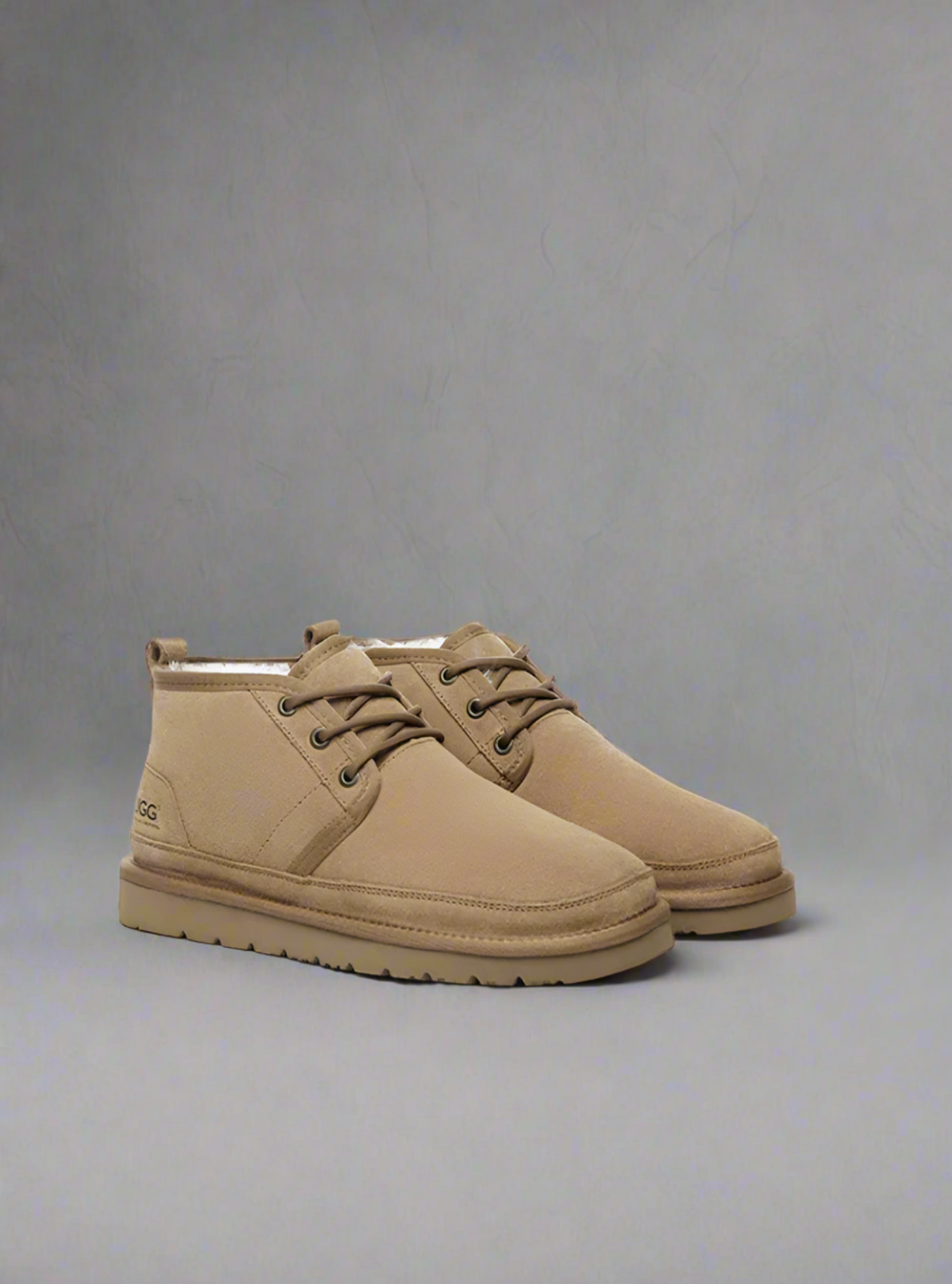 Pair of tan boots on a gray background