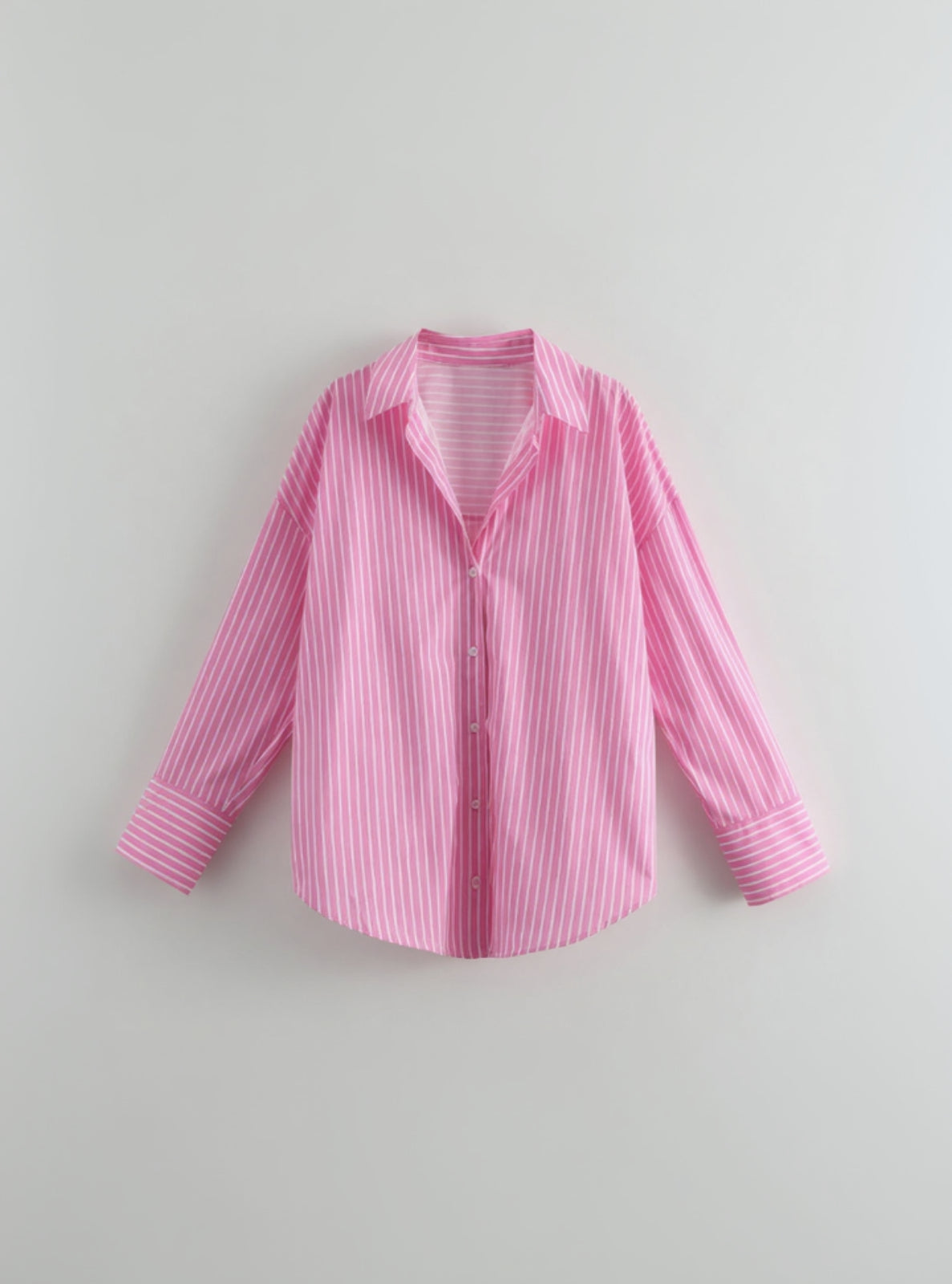 Pink and white striped shirt on a light gray background