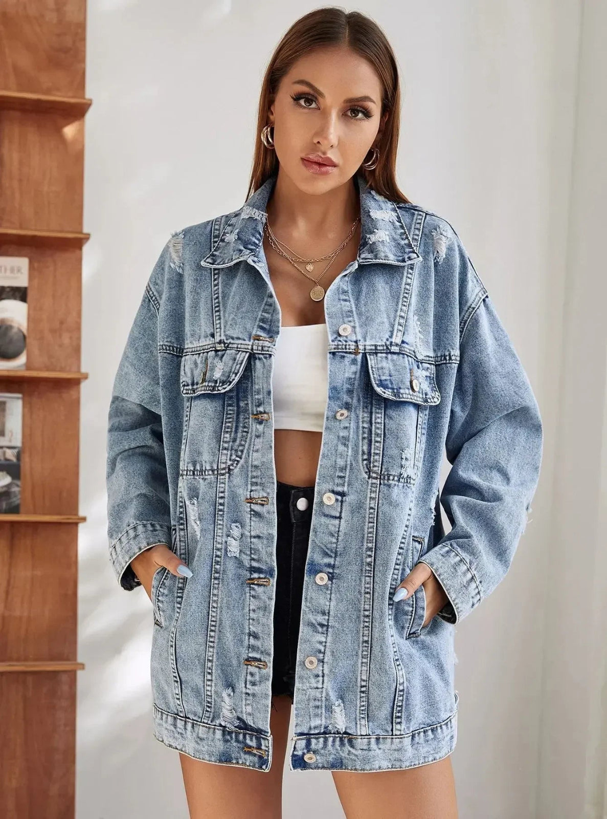 Woman wearing a light blue denim jacket against a neutral background