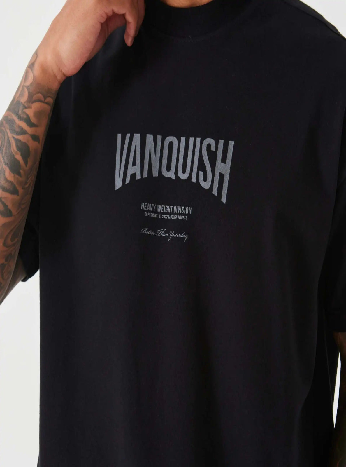 Black t-shirt with 'Vanquish' logo worn by a person with tattoos on a white background