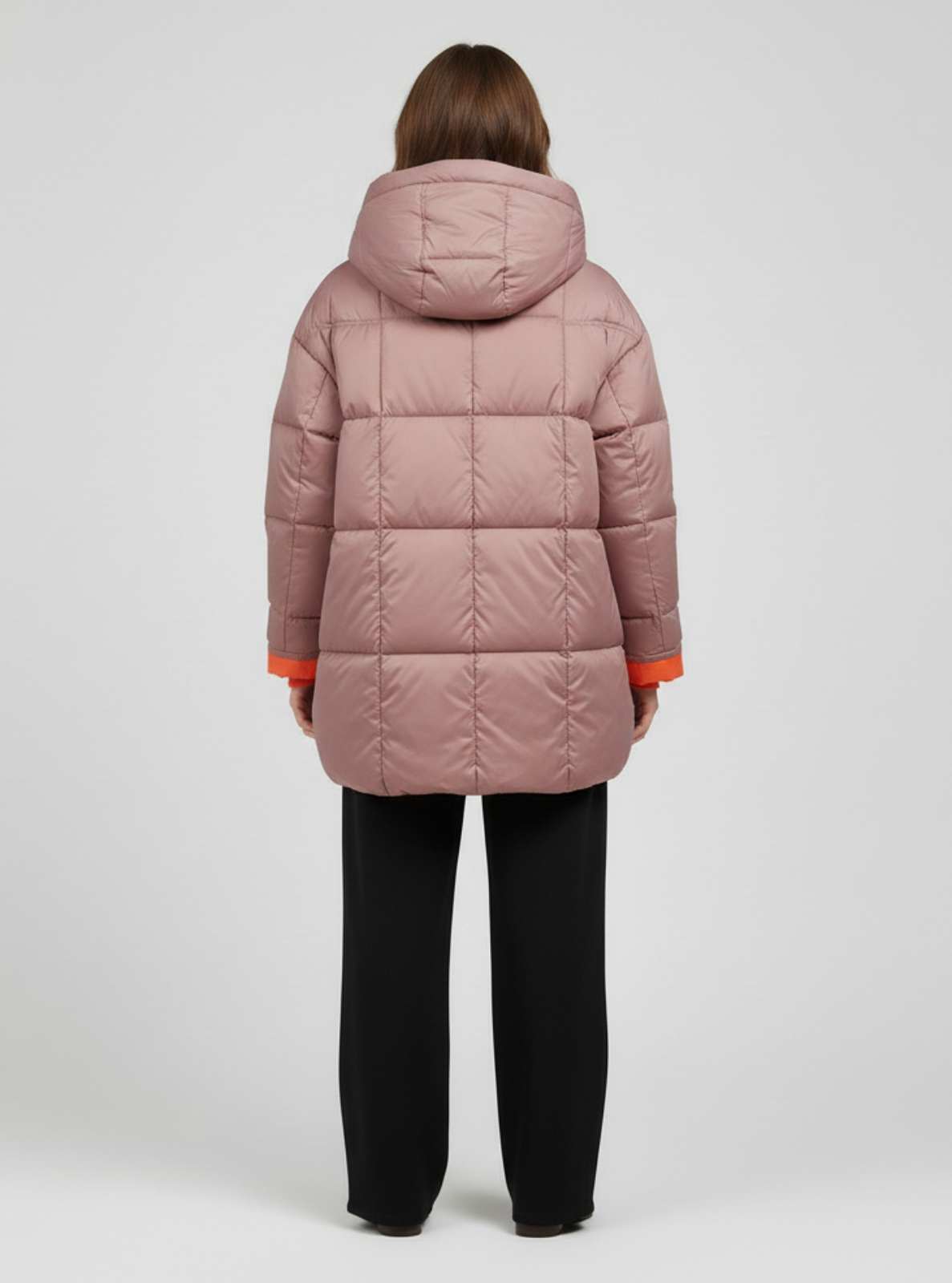 Person wearing a pink puffer coat with a hood on a white background