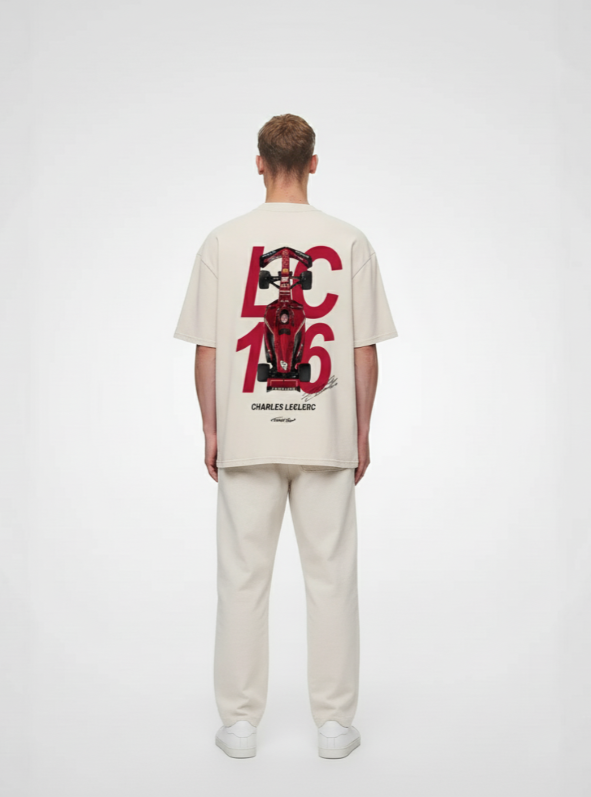 Person wearing a beige t-shirt with a graphic design on the back against a white background