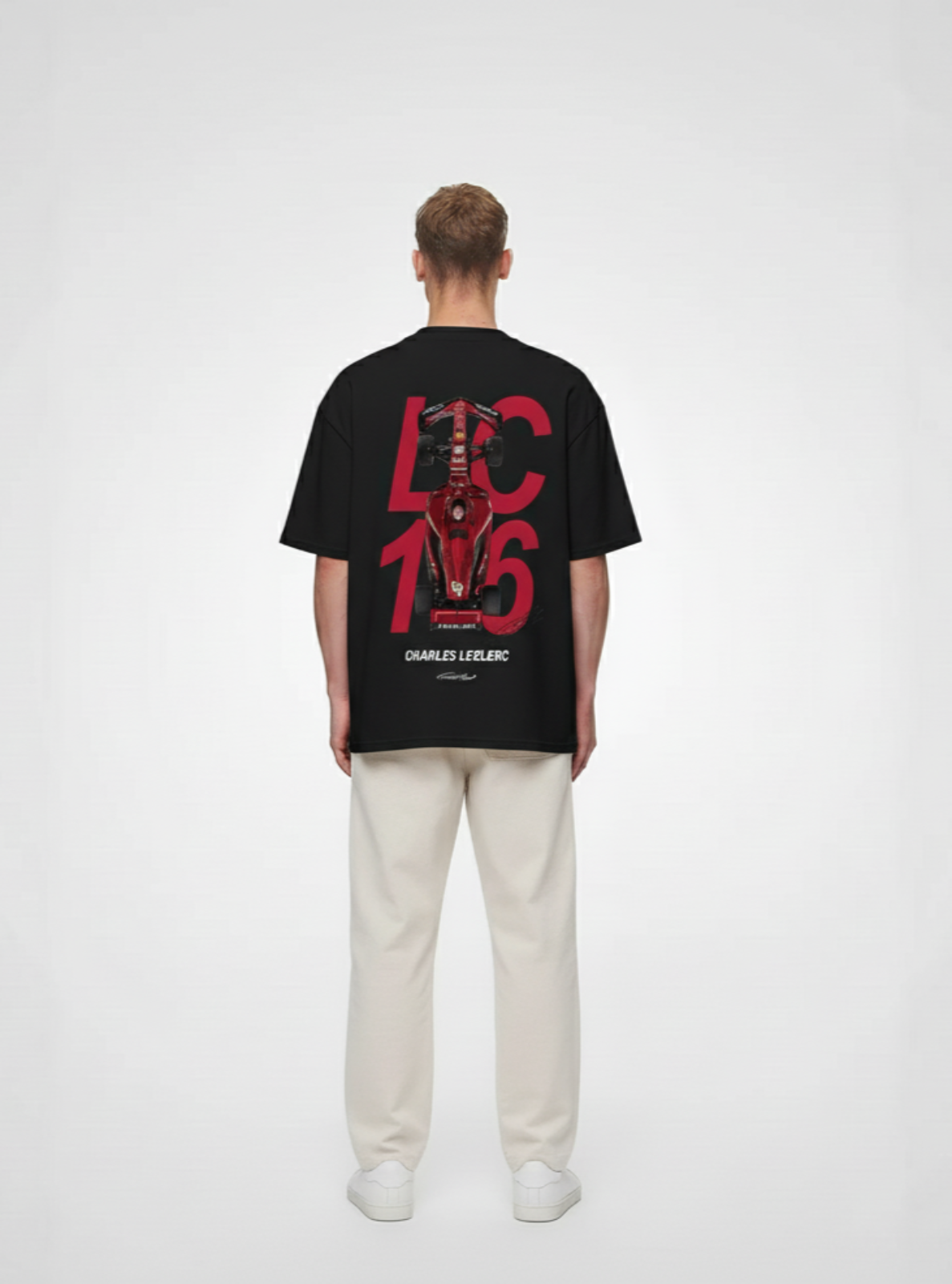 Person wearing a black t-shirt with red graphics on the back against a white background