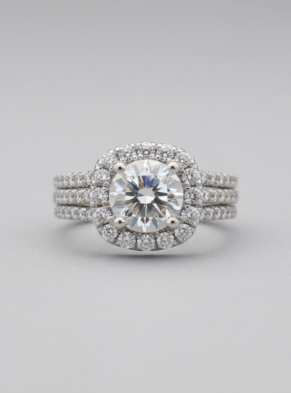 Diamond ring with a halo on a light gray background