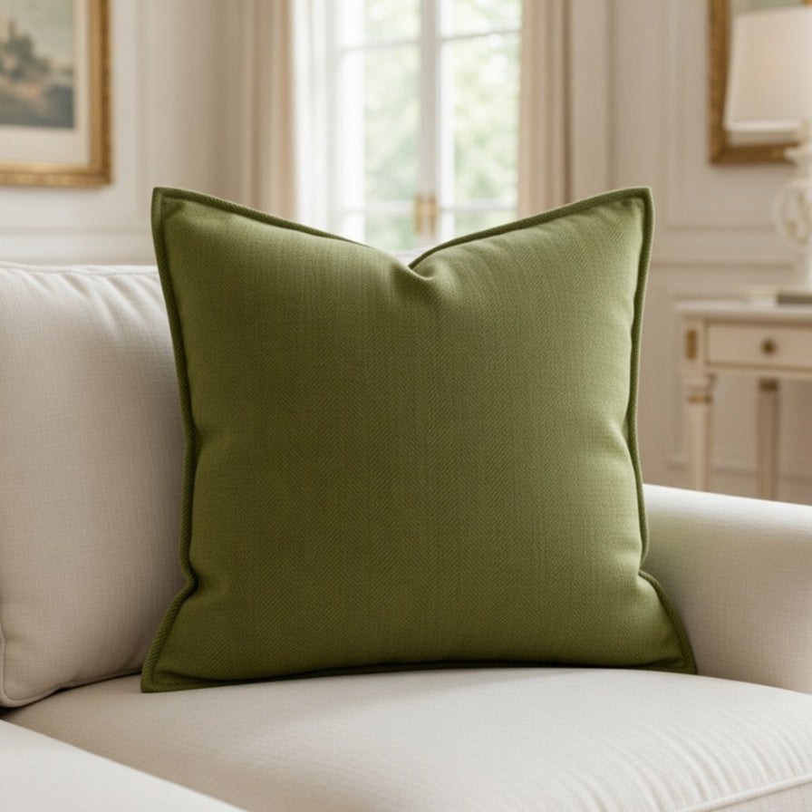 Green pillow on a beige sofa in a room with light decor