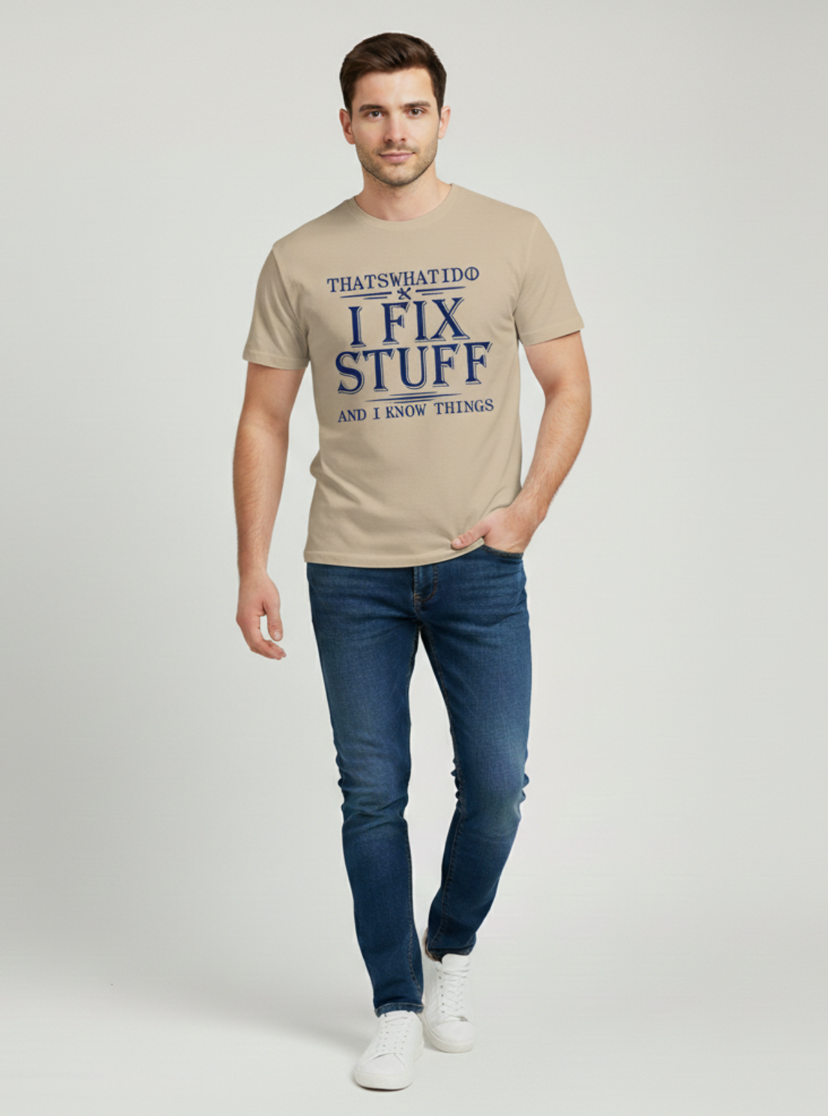 Man wearing a beige t-shirt with text and blue jeans on a light gray background