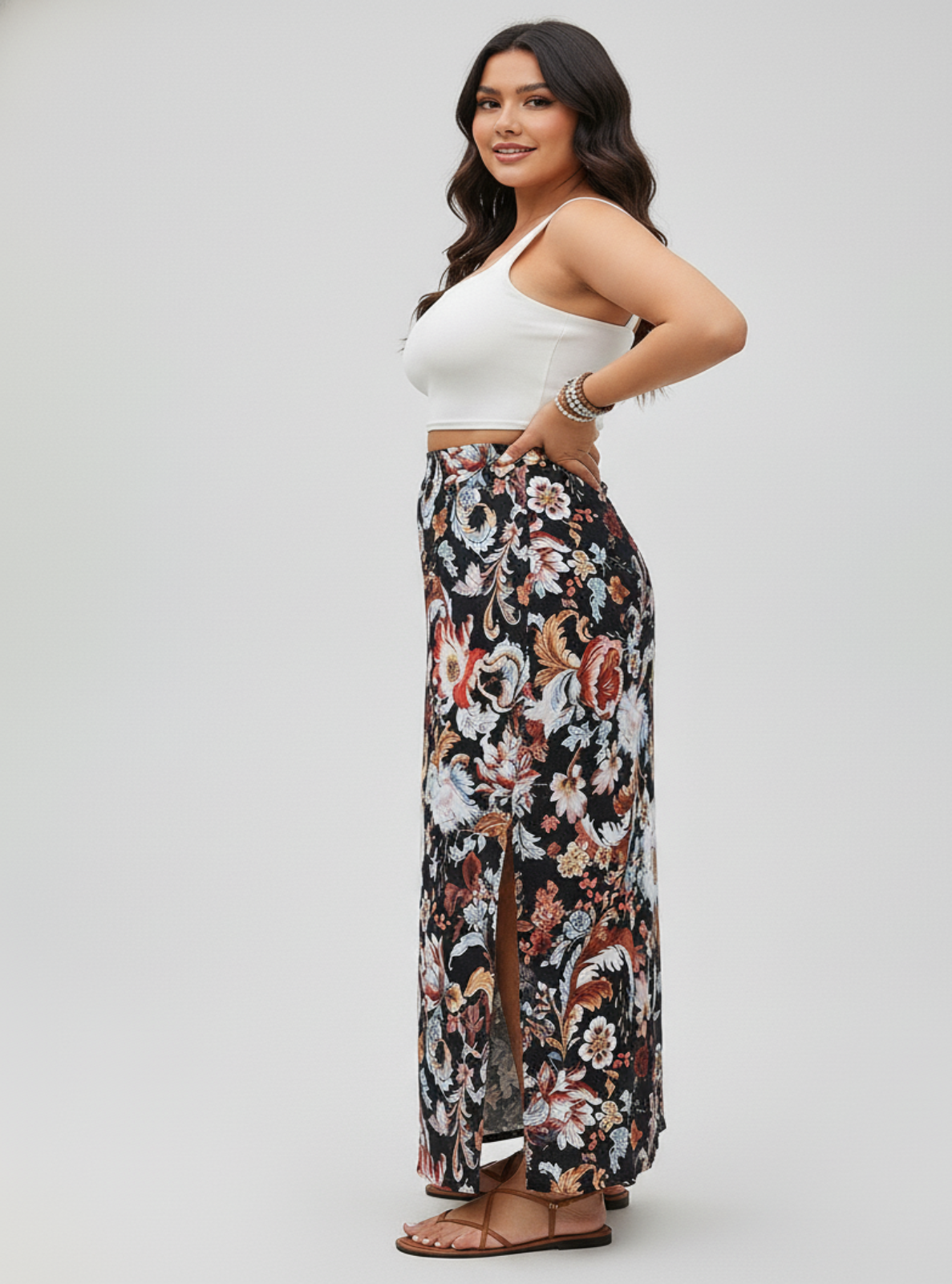 Woman wearing a white top and floral pants on a gray background