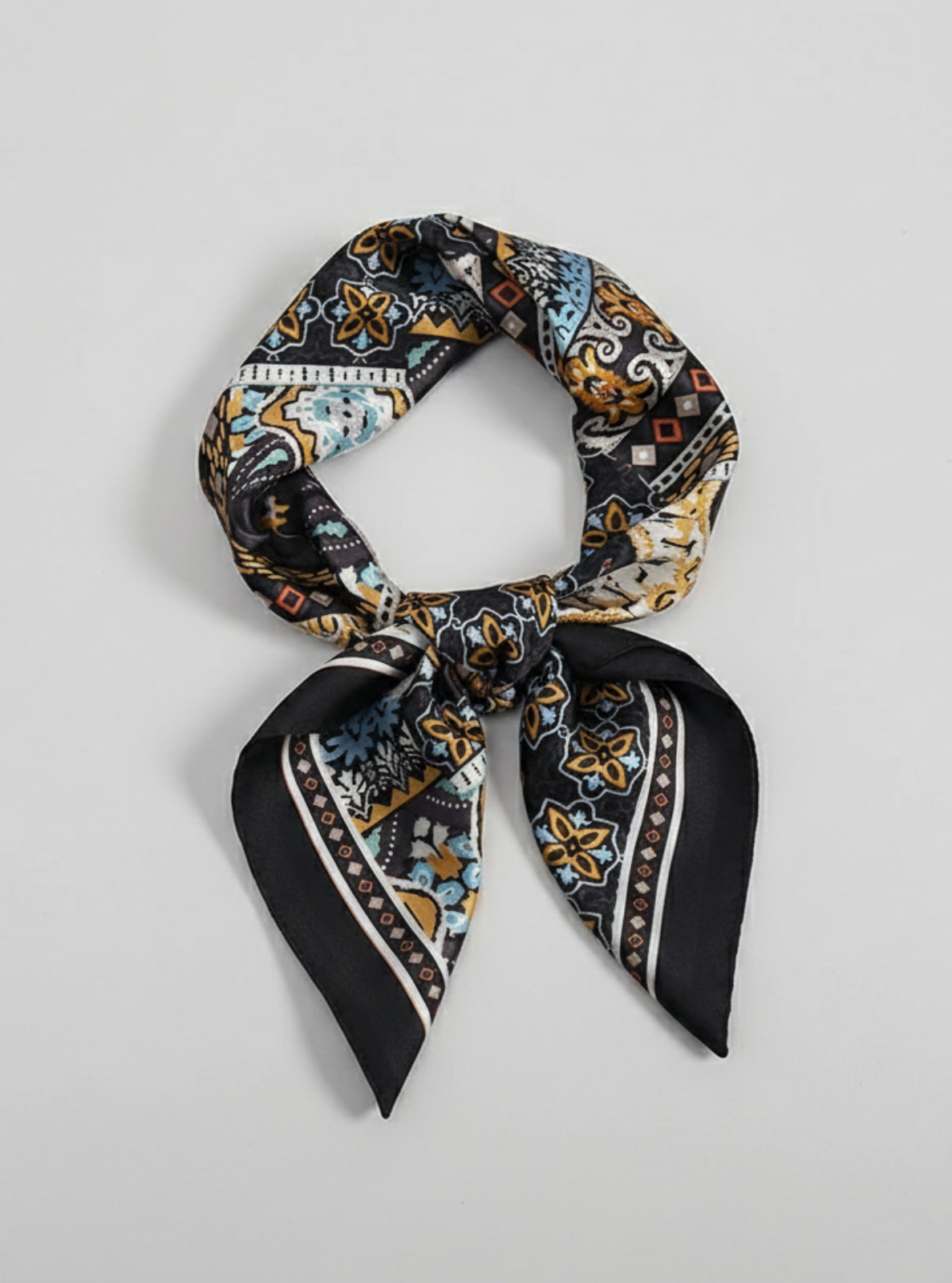 Patterned scarf tied in a knot on a light gray background