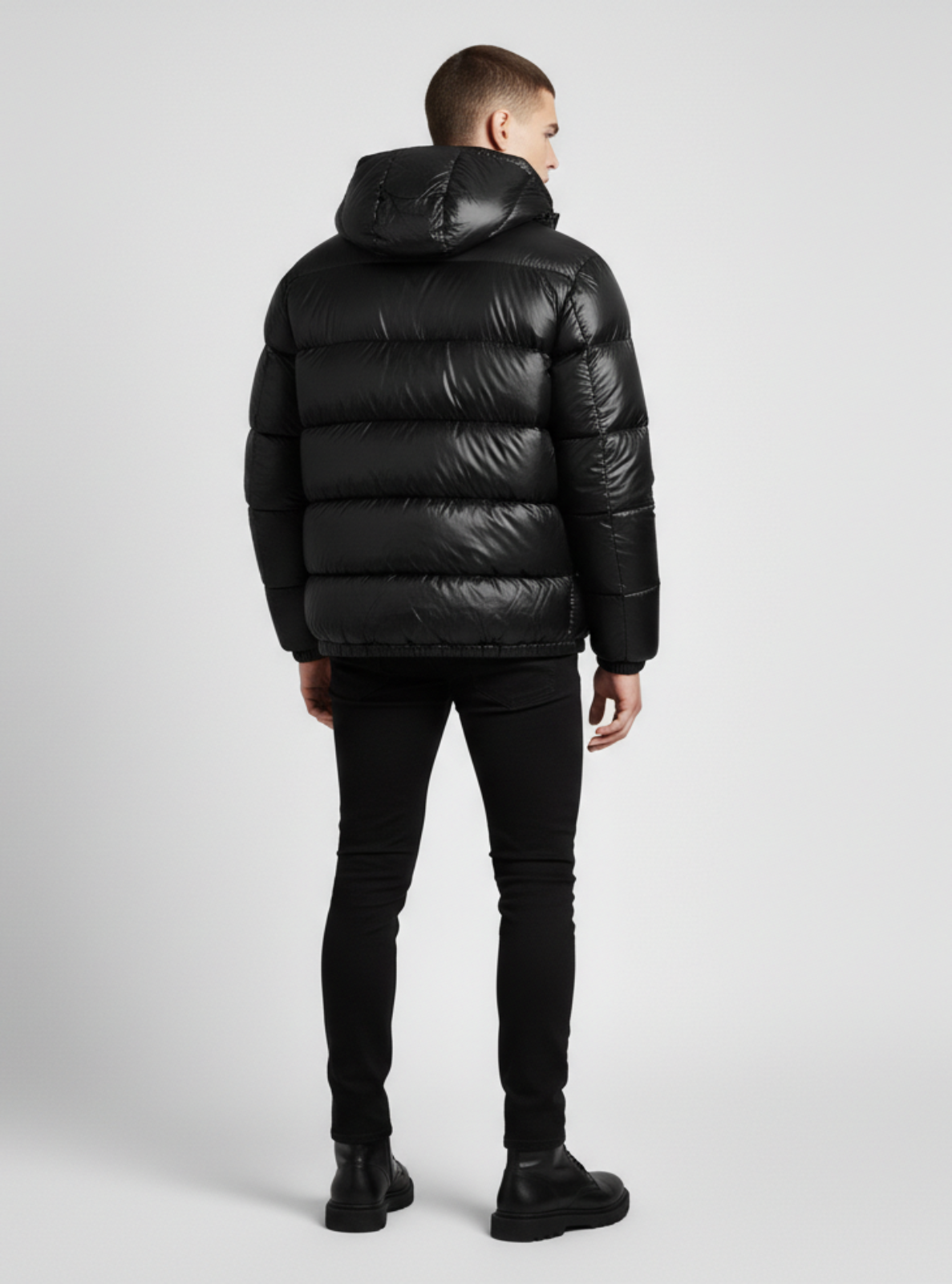 Person wearing a black puffer jacket on a light gray background