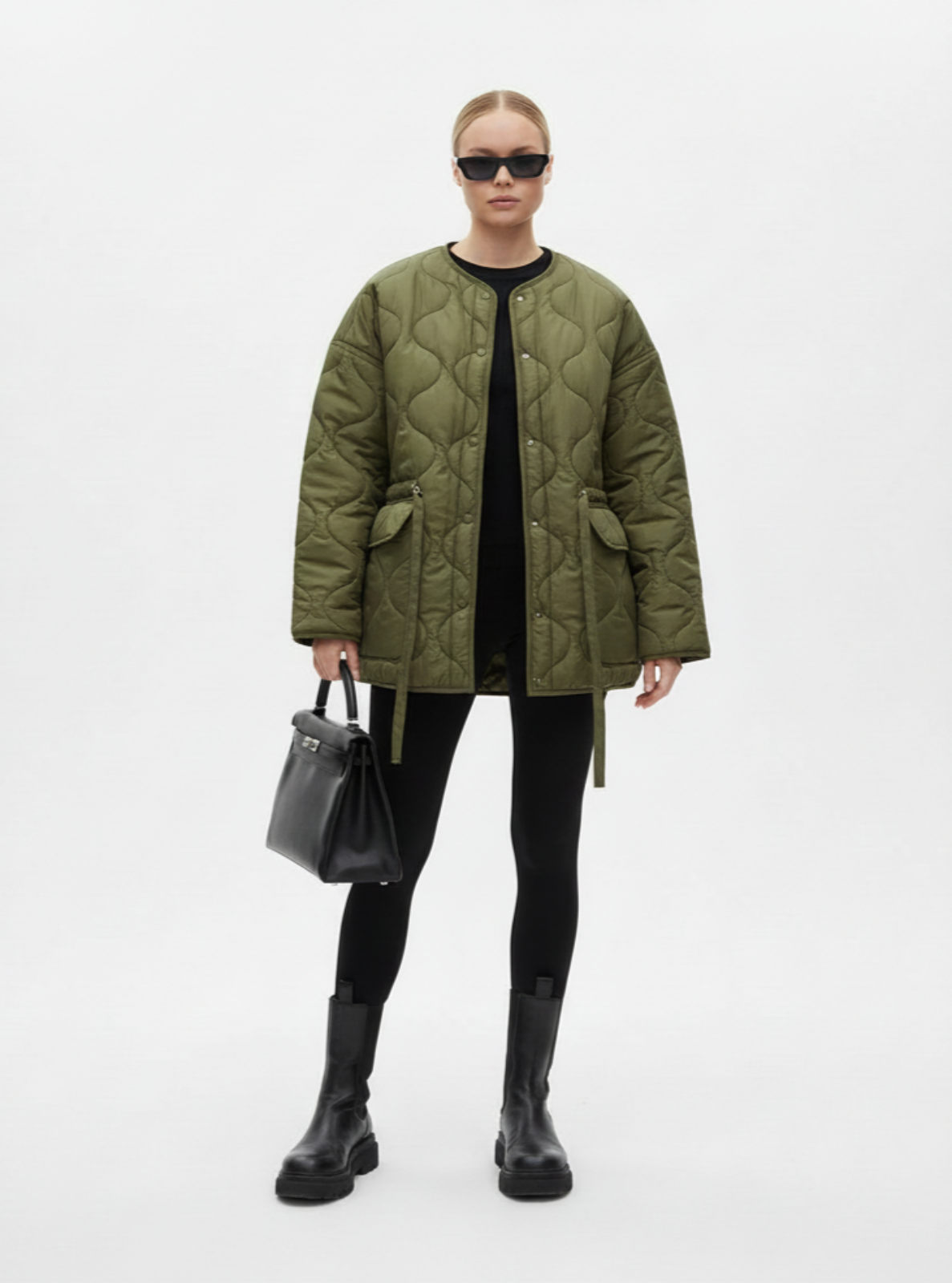 Person wearing a green quilted jacket on a white background