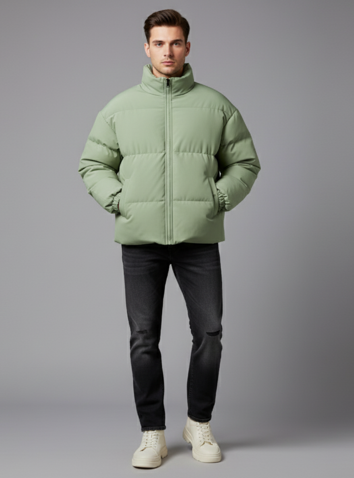 Man wearing a green puffer jacket on a gray background