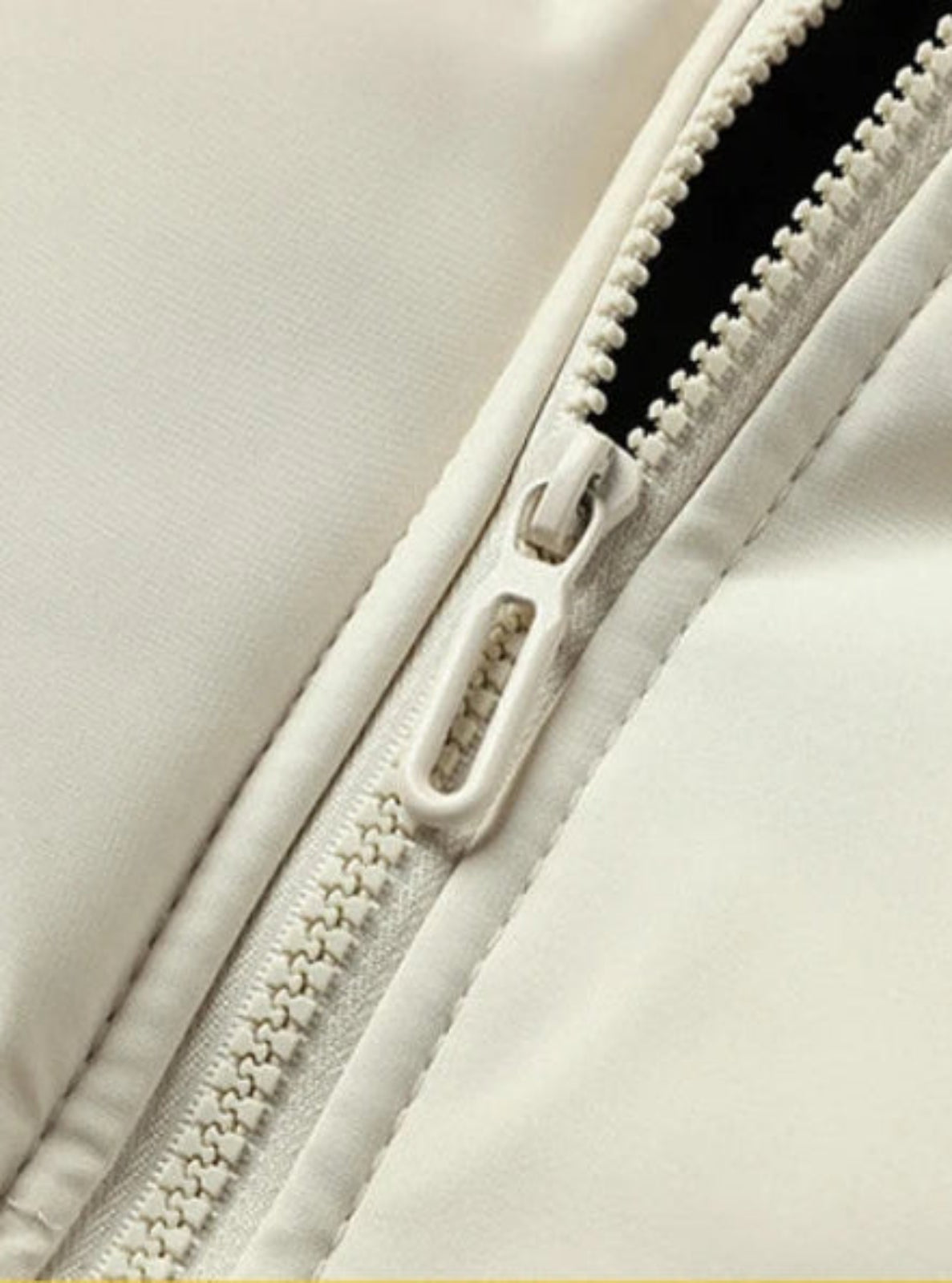 Close-up of a zipper on a beige garment