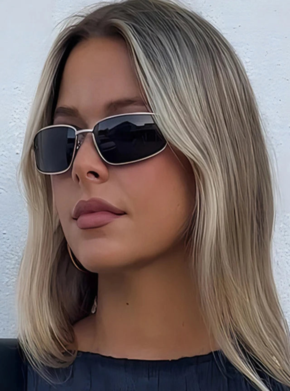 Woman wearing sunglasses with a plain white background