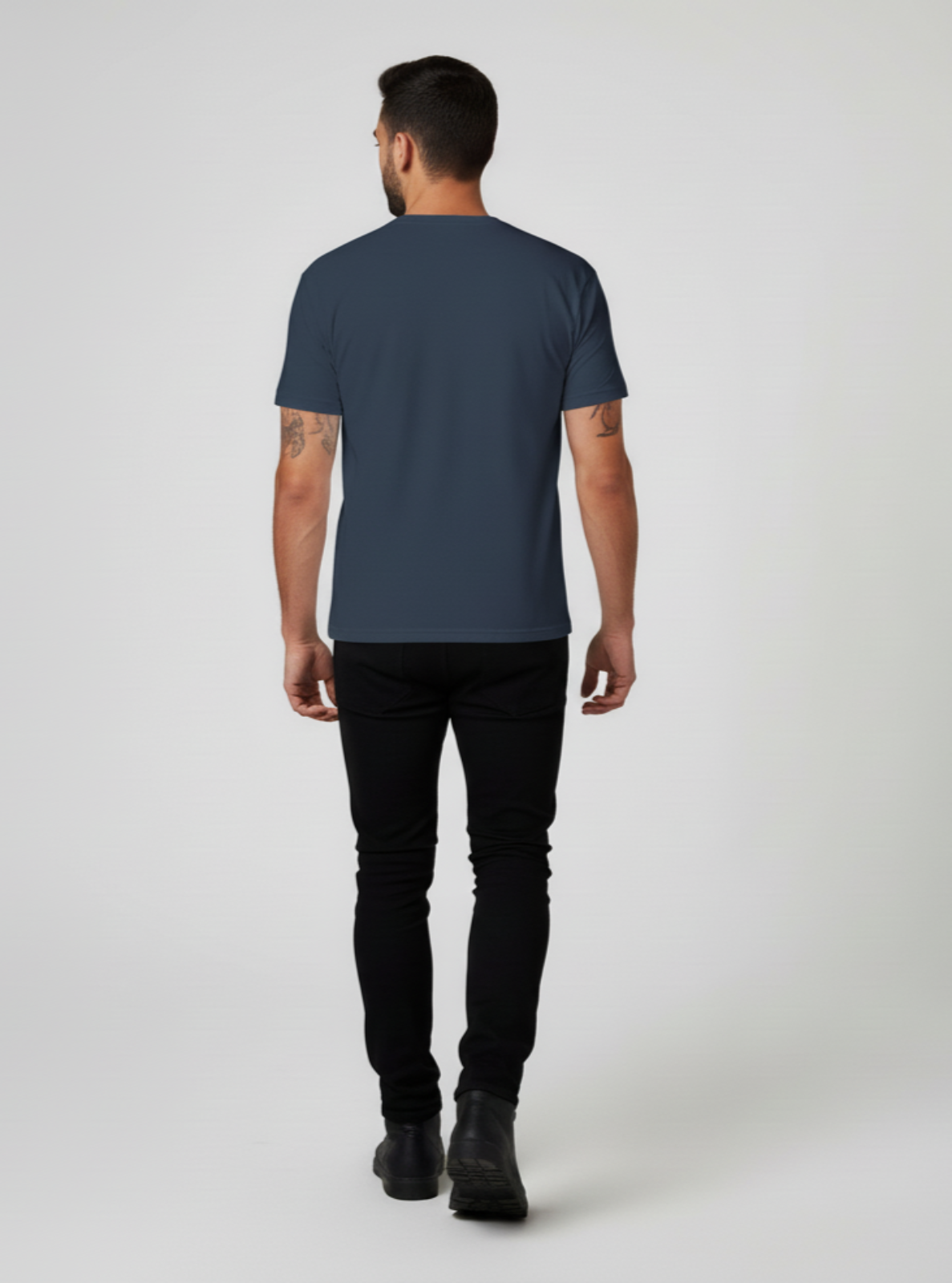 Man wearing a dark blue t-shirt and black pants on a white background