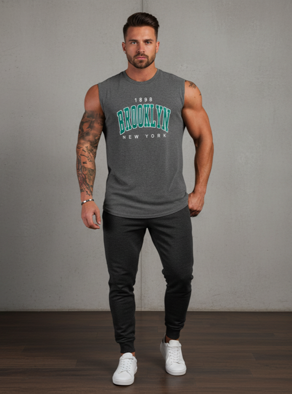 Man wearing a gray sleeveless shirt with 'Brooklyn New York' text against a plain background