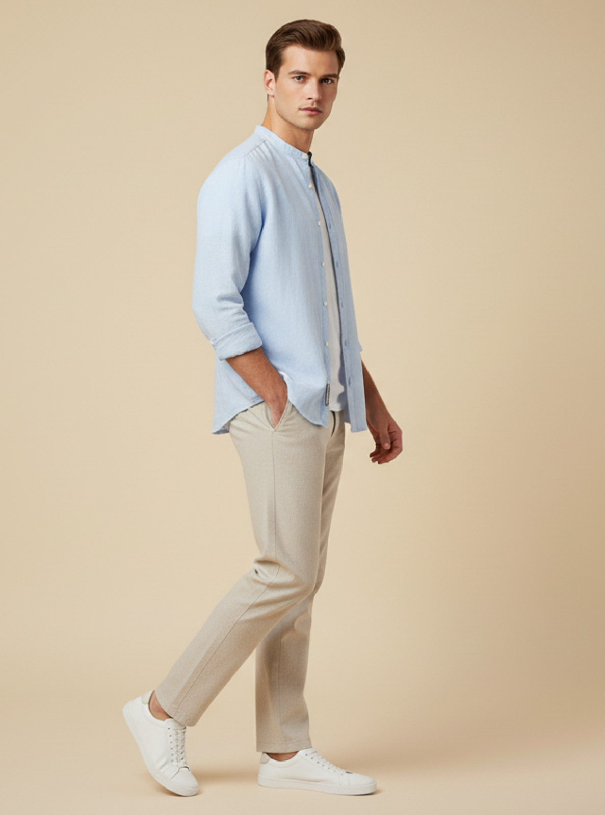 Man wearing a light blue shirt and beige pants on a beige background