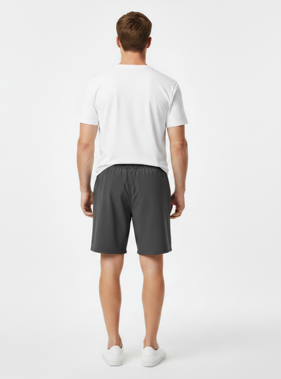 Man wearing a white t-shirt and gray shorts on a white background