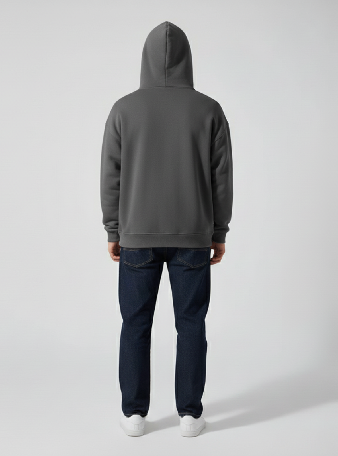 Person wearing a gray hoodie and dark pants on a light gray background