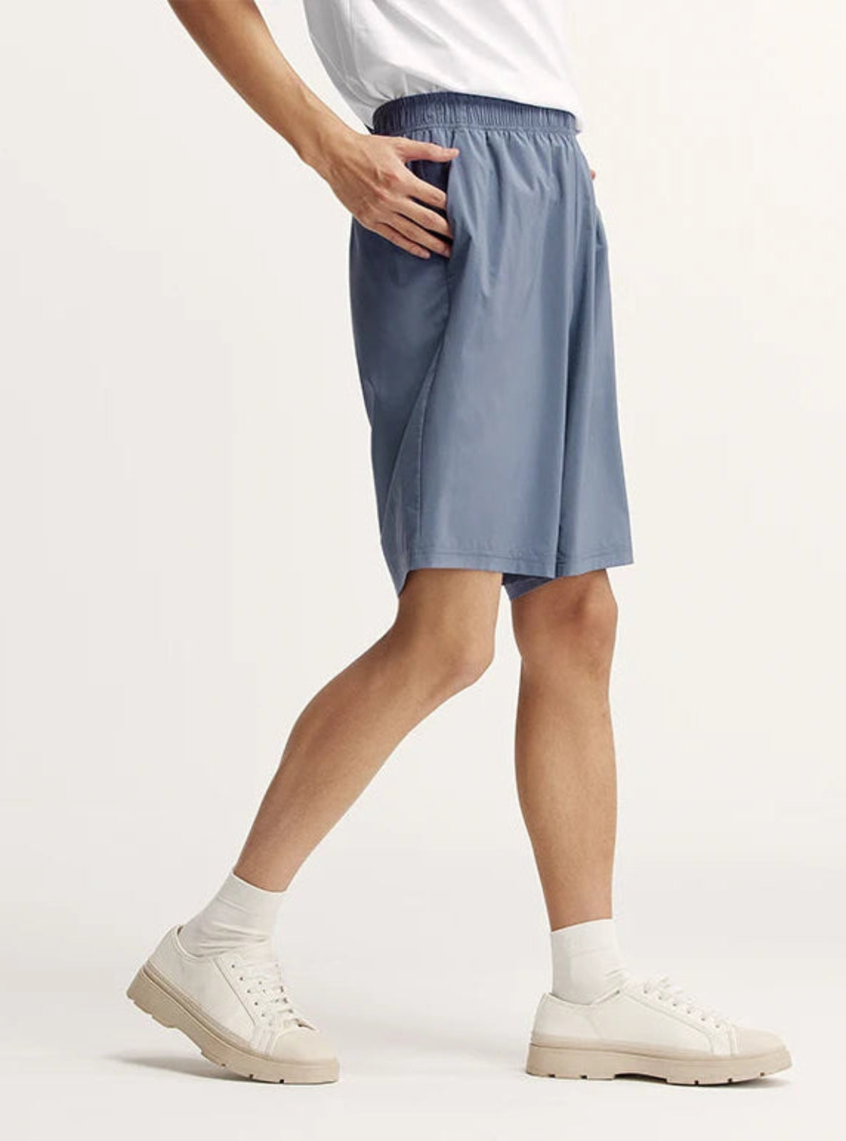 Person wearing light blue shorts on a white background