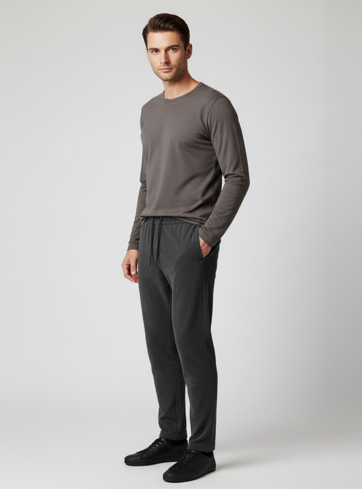 Man wearing a gray long-sleeve shirt and pants on a light gray background